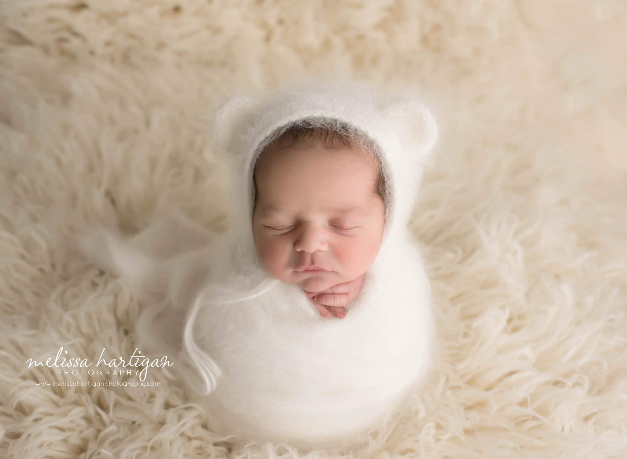 Newborn baby boy wrapped in white knitted wrap with matching bear bonnet Hartford county Newborn photographer