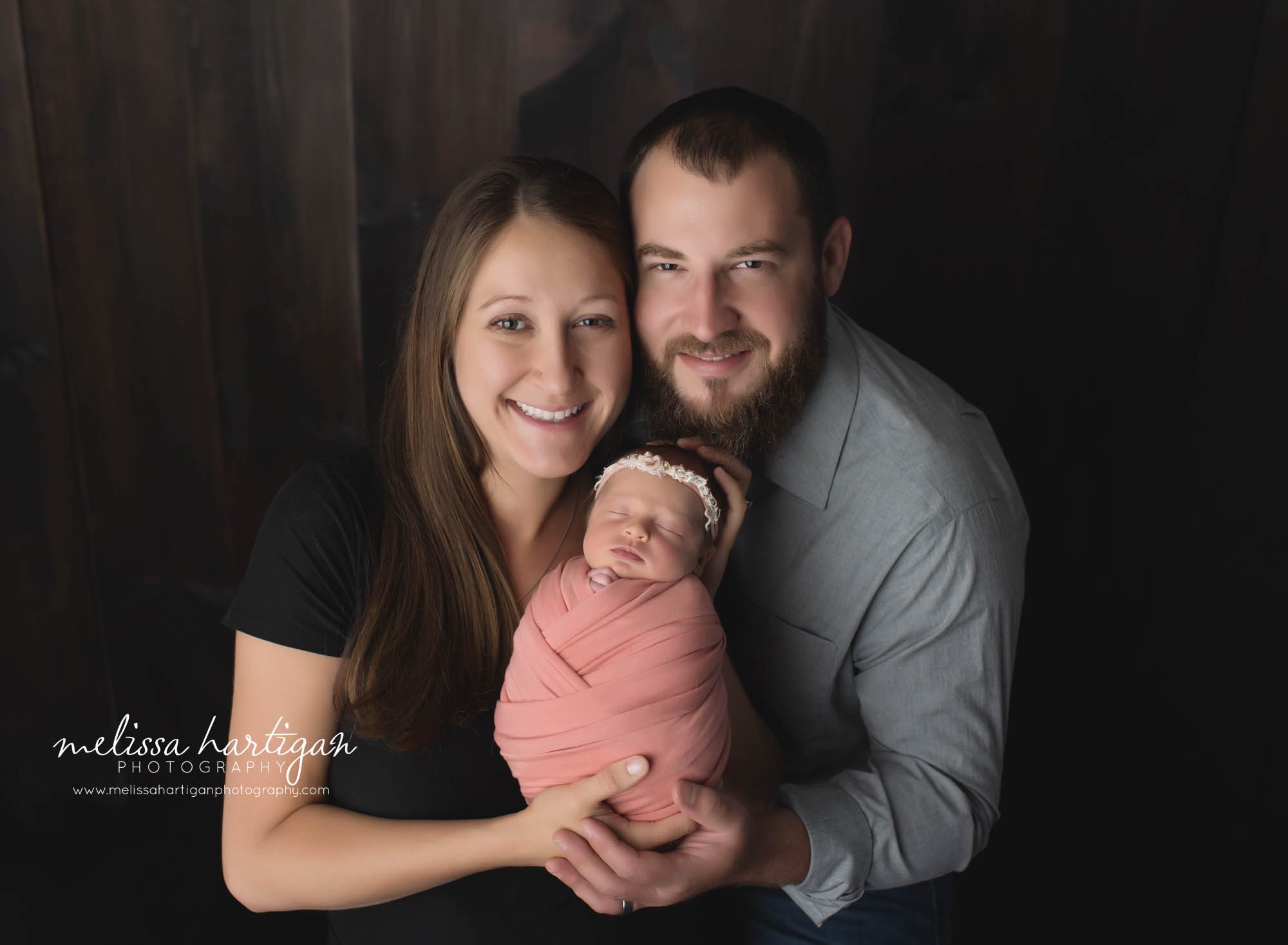 mom dad and newborn baby girl wrapped in coral color family photo Newborn photography session in tolland county CT
