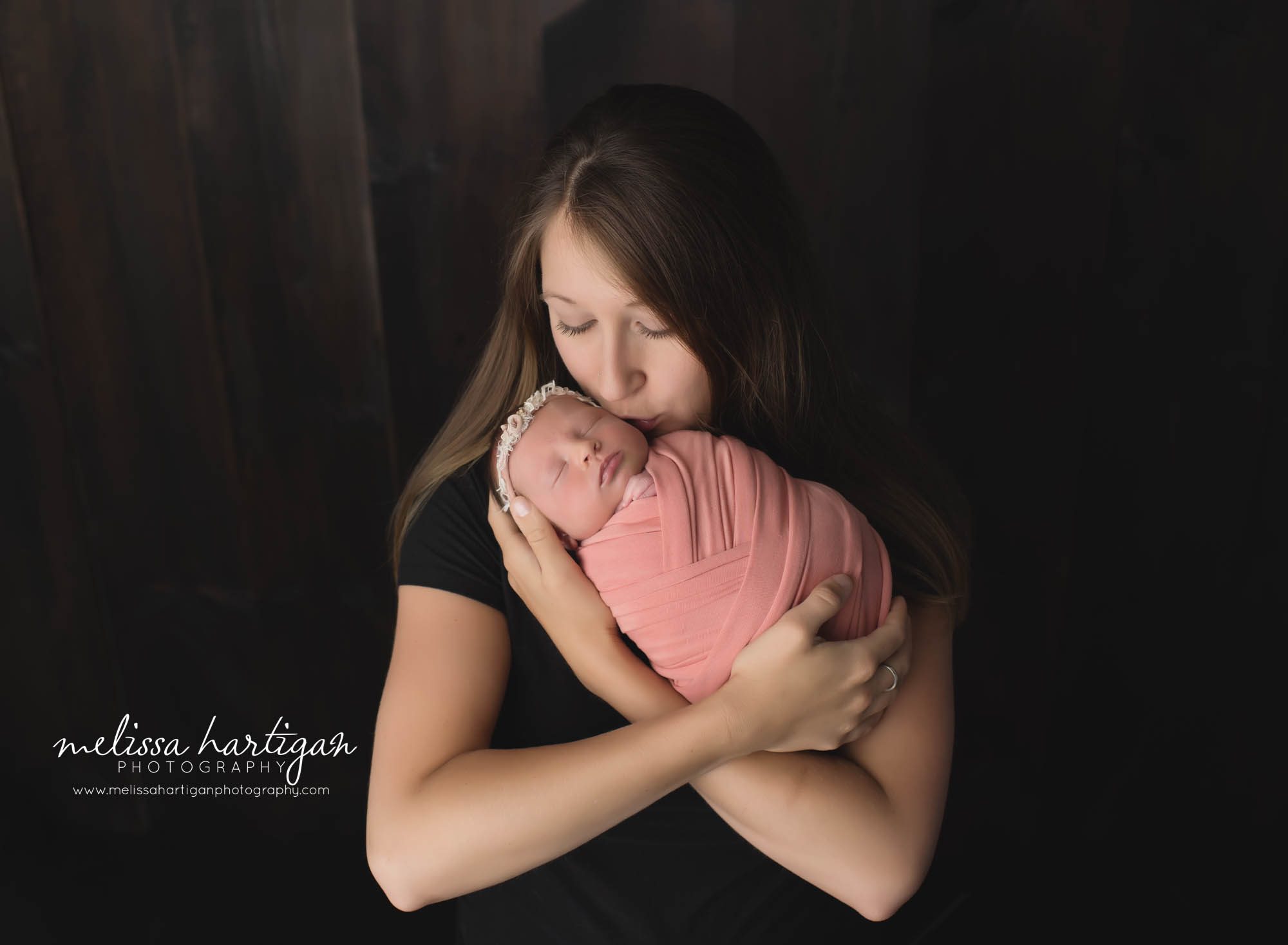 mom holding newborn daughter kissing her on cheek Newborn family photography CT