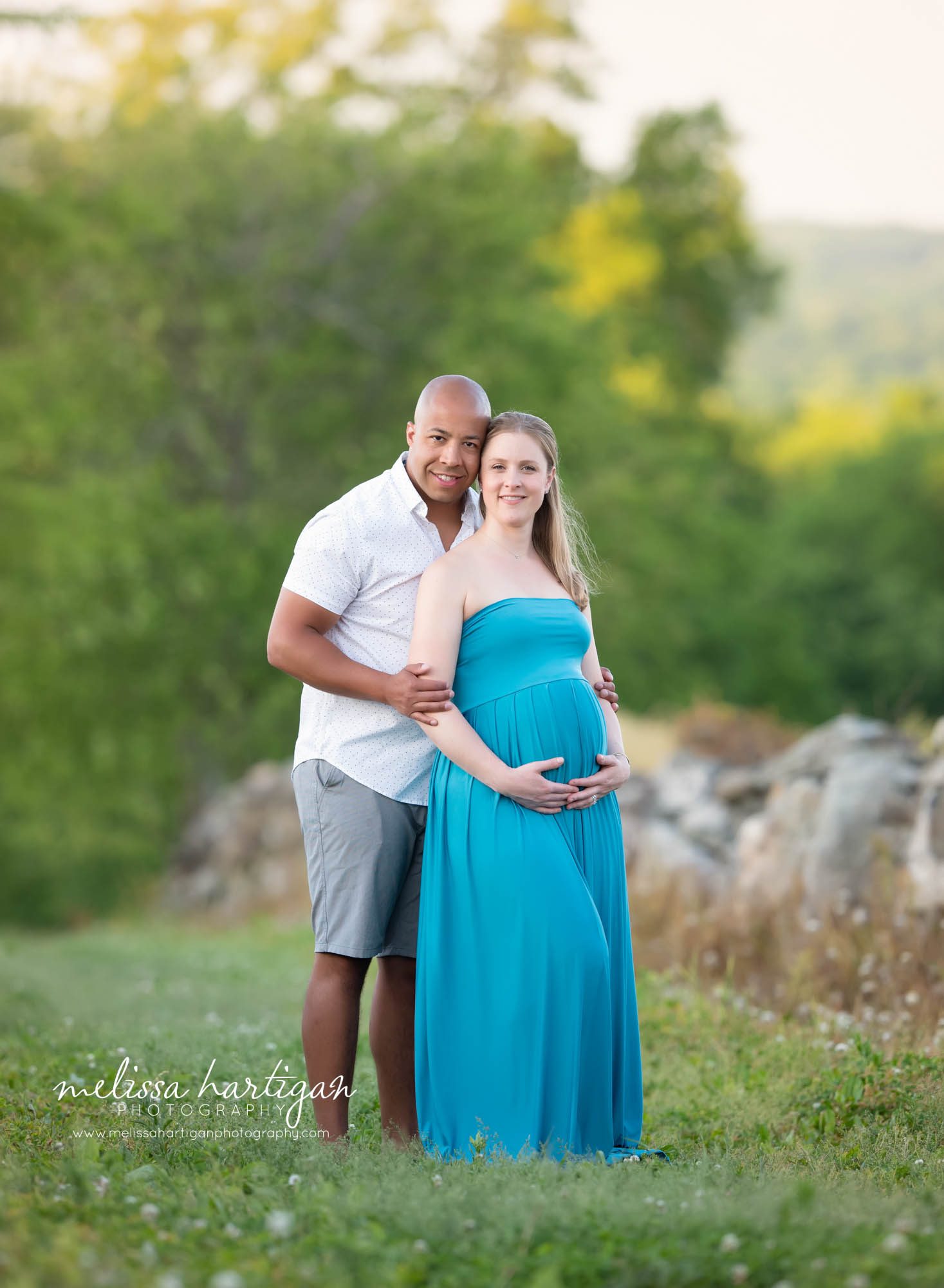 pregnant mom leaning against dad, dad-to-be holding moms arms smiling for couples picture CT maternity photography