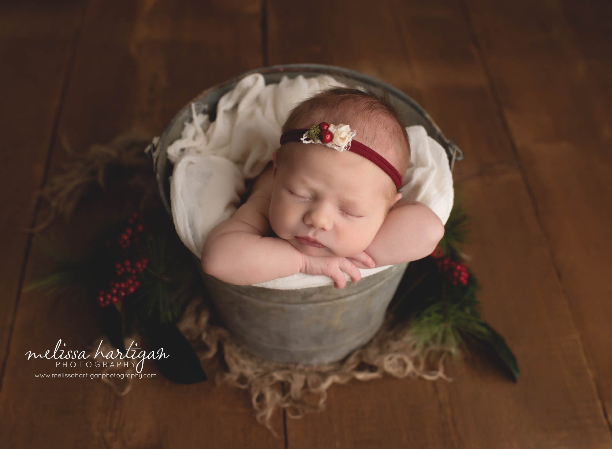Newborn baby girl posed in bucket with chin on hands red christmas headband Connecticut Newborn Photography