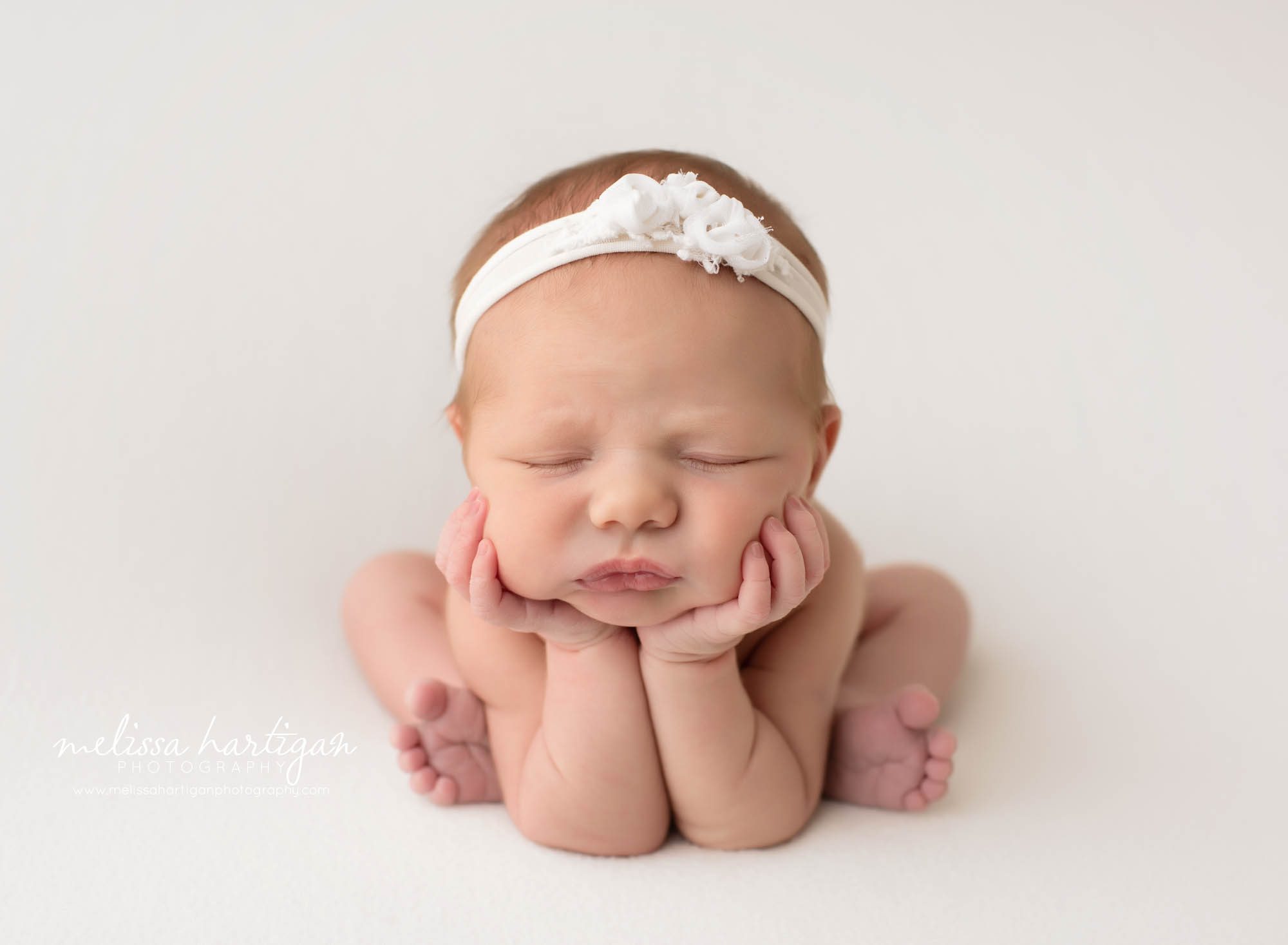 Newborn baby girl posed froggy pose white headband Mansfield CT baby photography