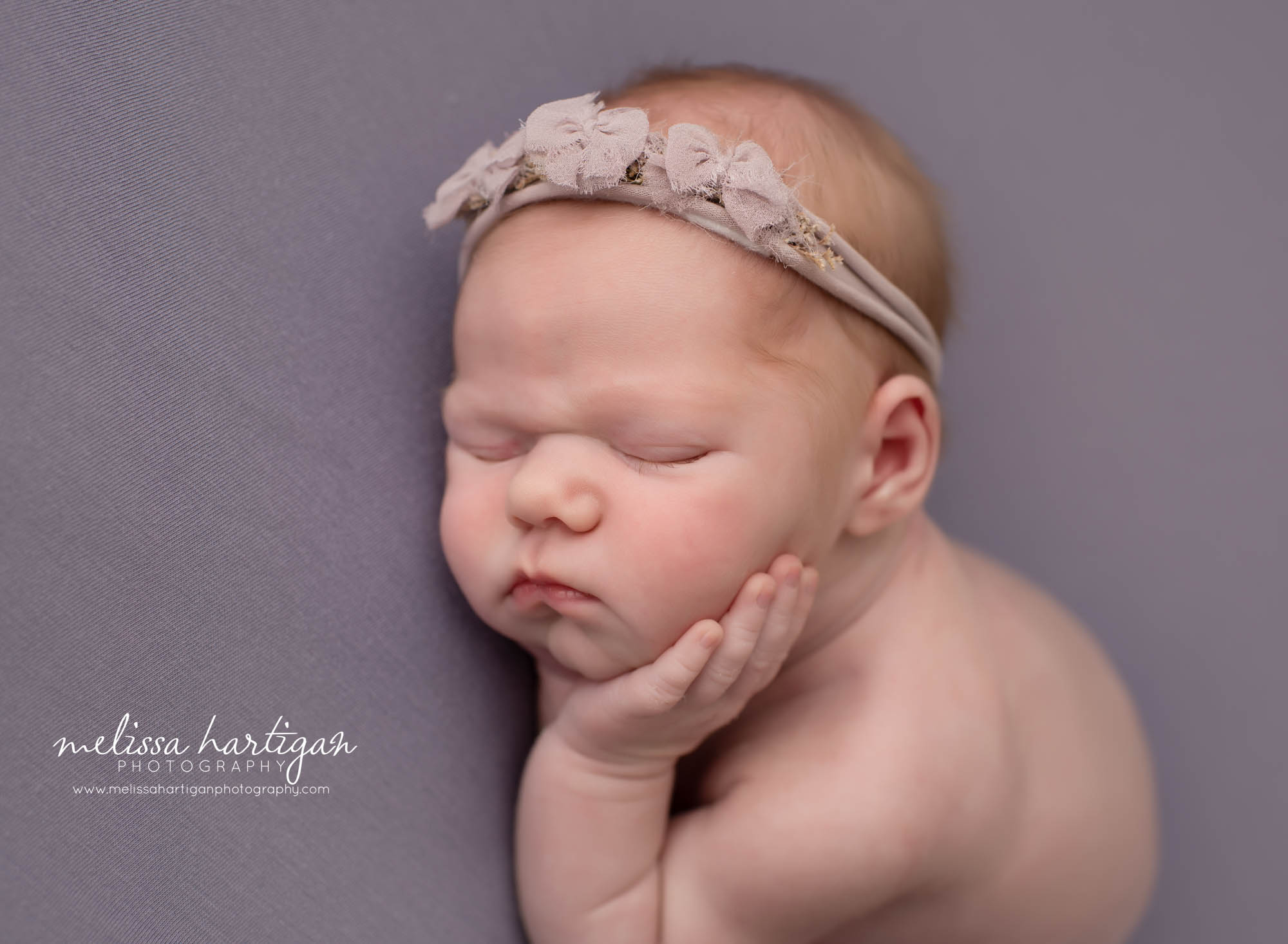 newborn baby girl posed on side with hand under chin Newborn Photography CT