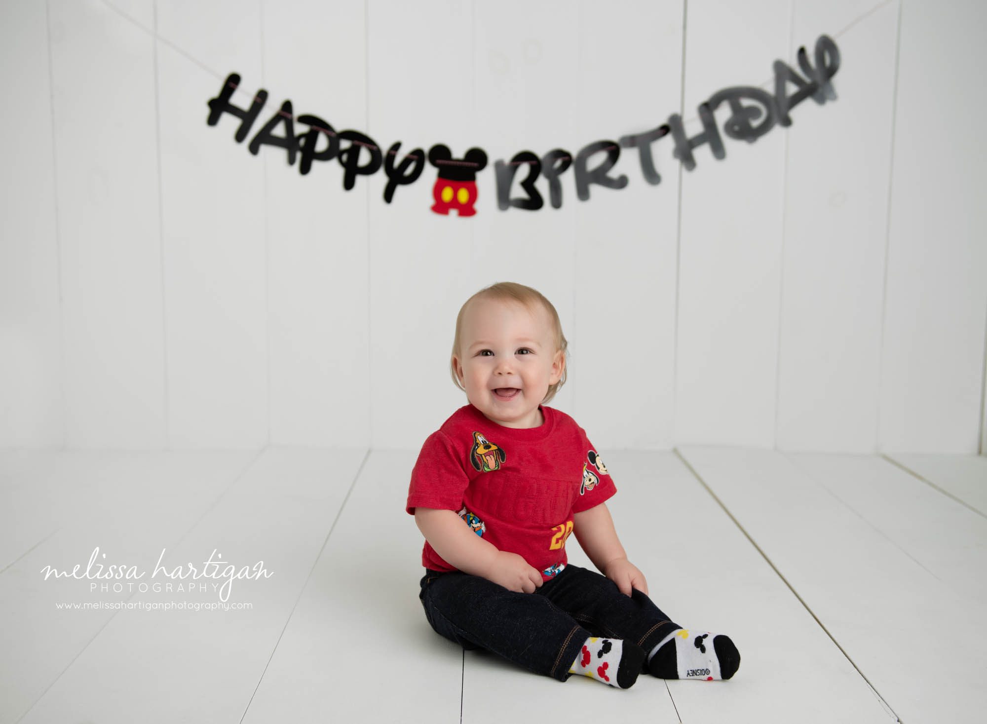 baby boy sitting on wooden boards in studio with happy birthday sign behind him baby cake smash Photographers Columbia CT