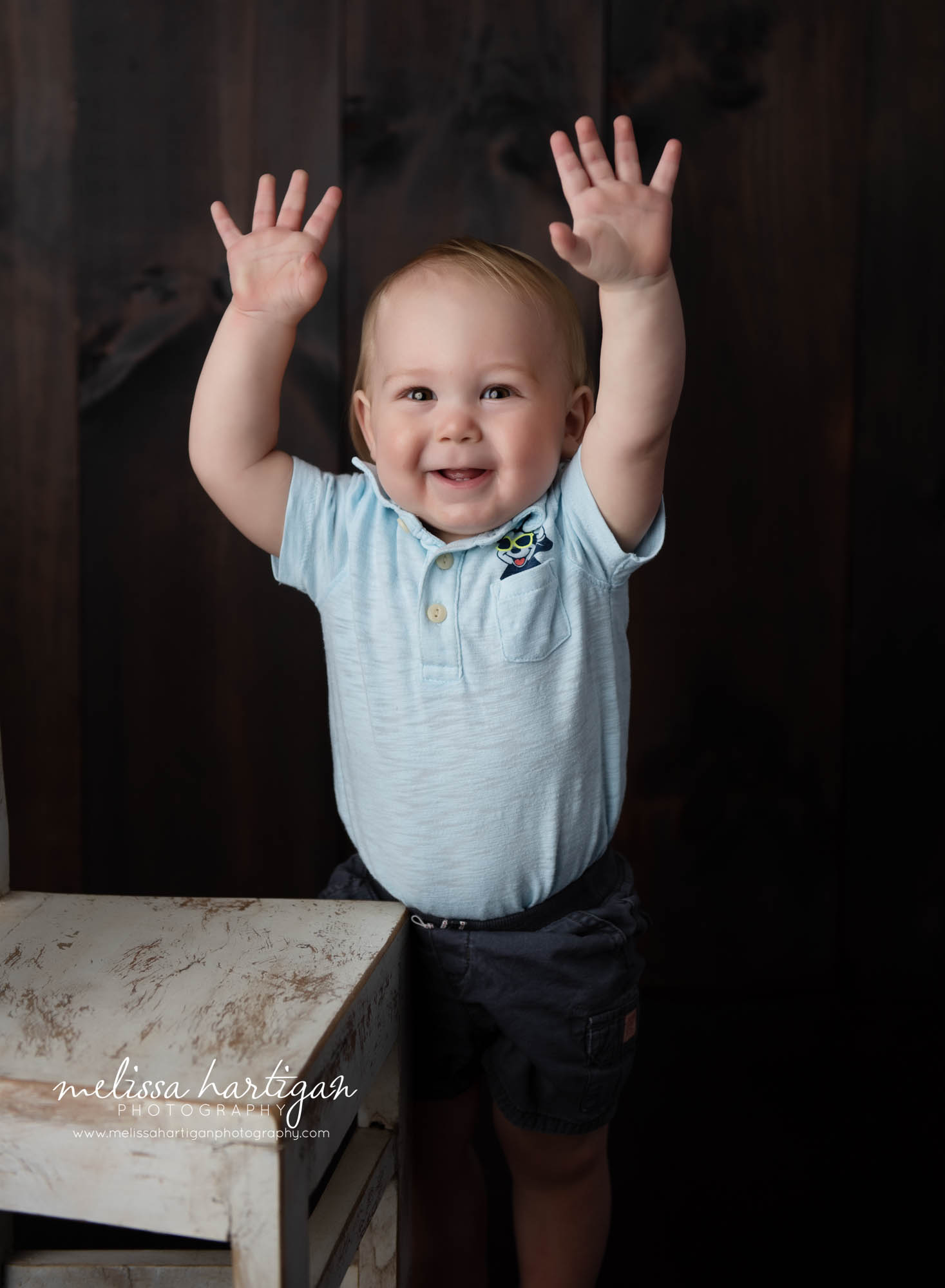 baby boy holding hands up in the air baby milestone photography session