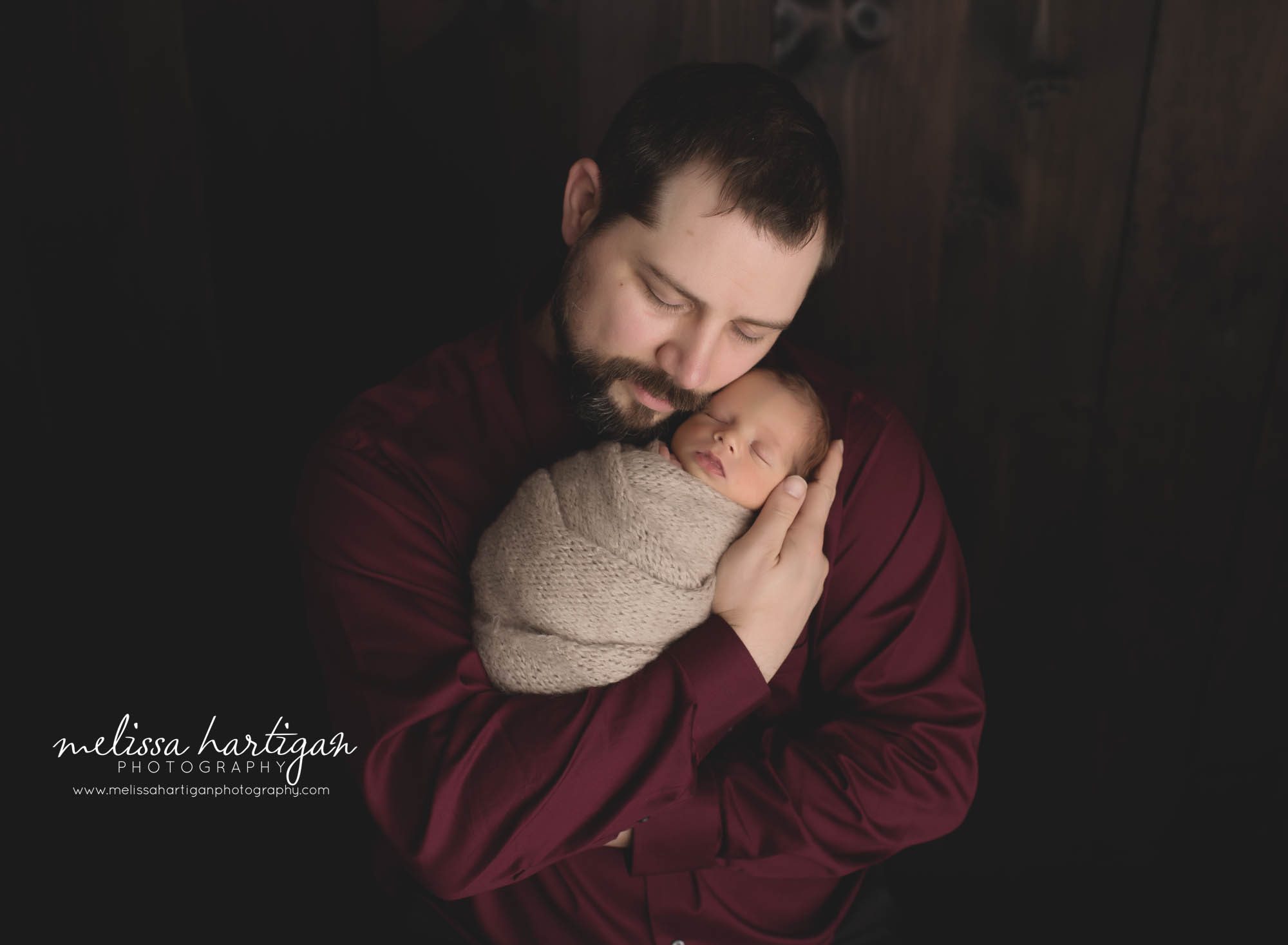 dad holding newborn son in parent pose newborn photography