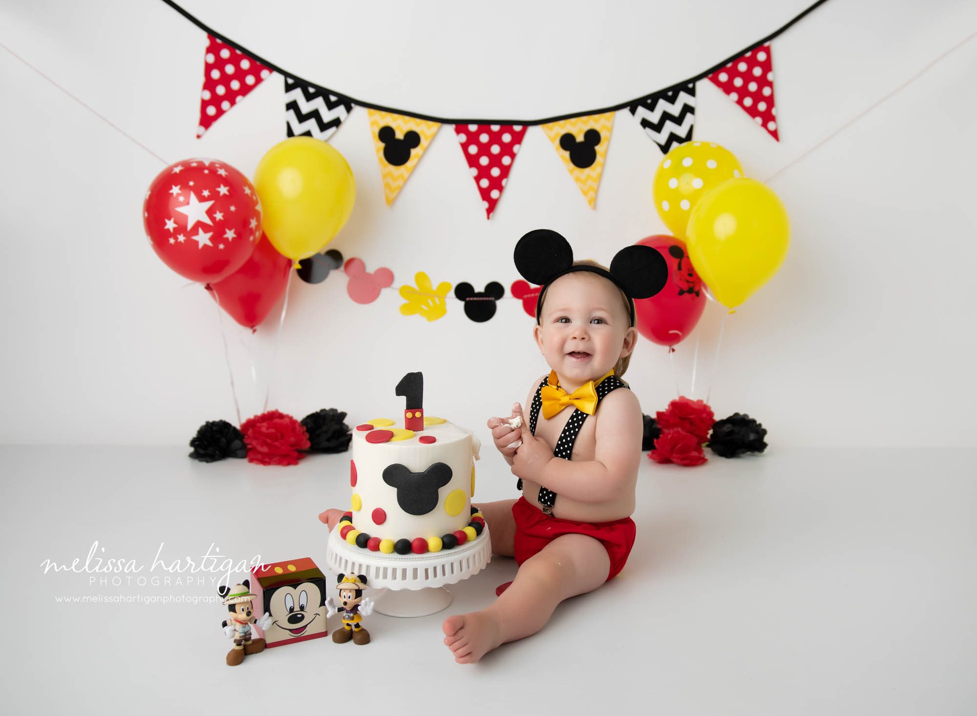 baby boy sitting on floor with mickey mouse cake smash theme