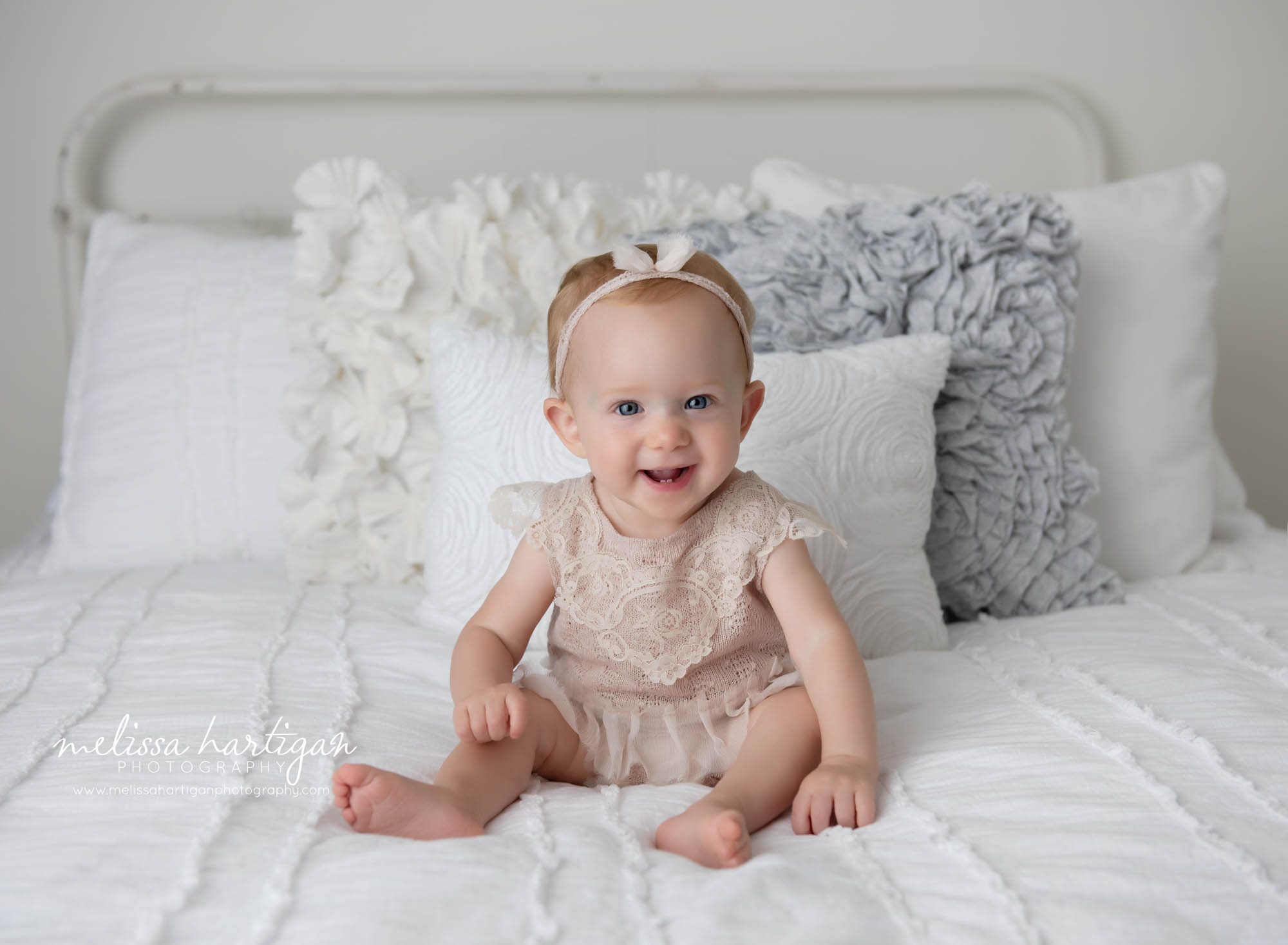 baby girl sitting on studio bed with lace outfit on colchester CT baby photographer