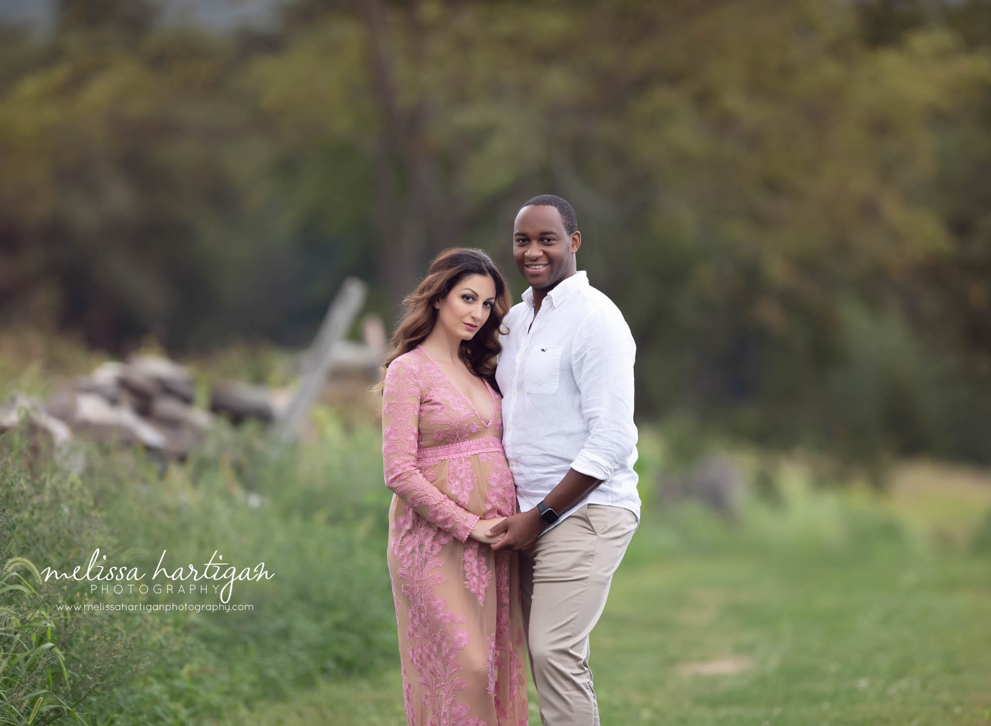 mom and dad to be holding hands looking at camera happy couple Newbington CT maternity photography