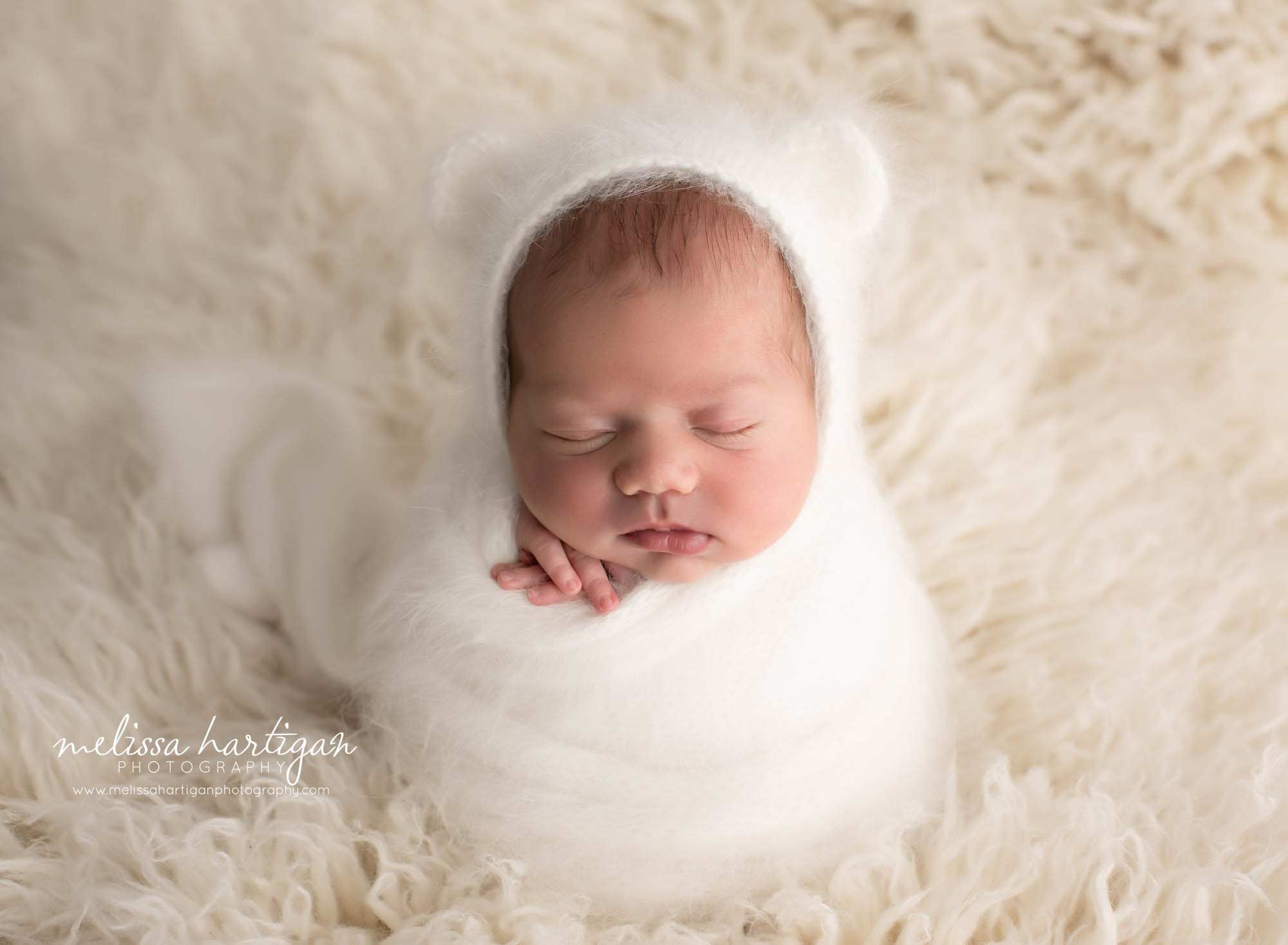 Newborn baby boy wrapped in white knitted wrap with matching angora knitted bear bonnet Stratford CT newborn Photography