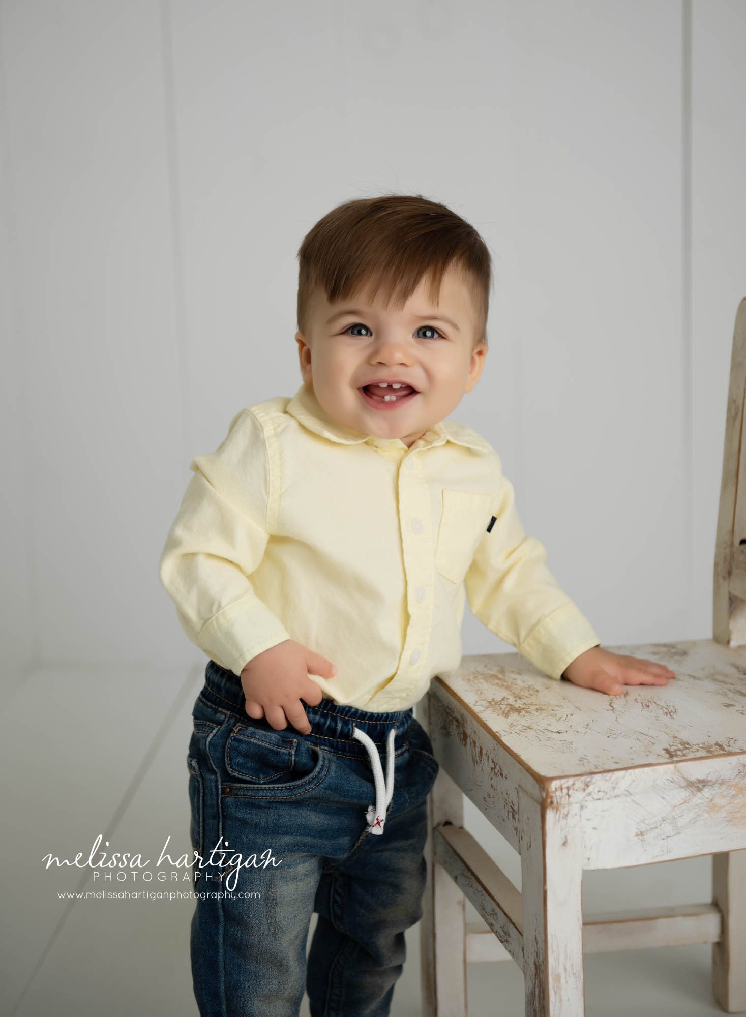 one year old baby boy standing at chair smiling CT baby photographer