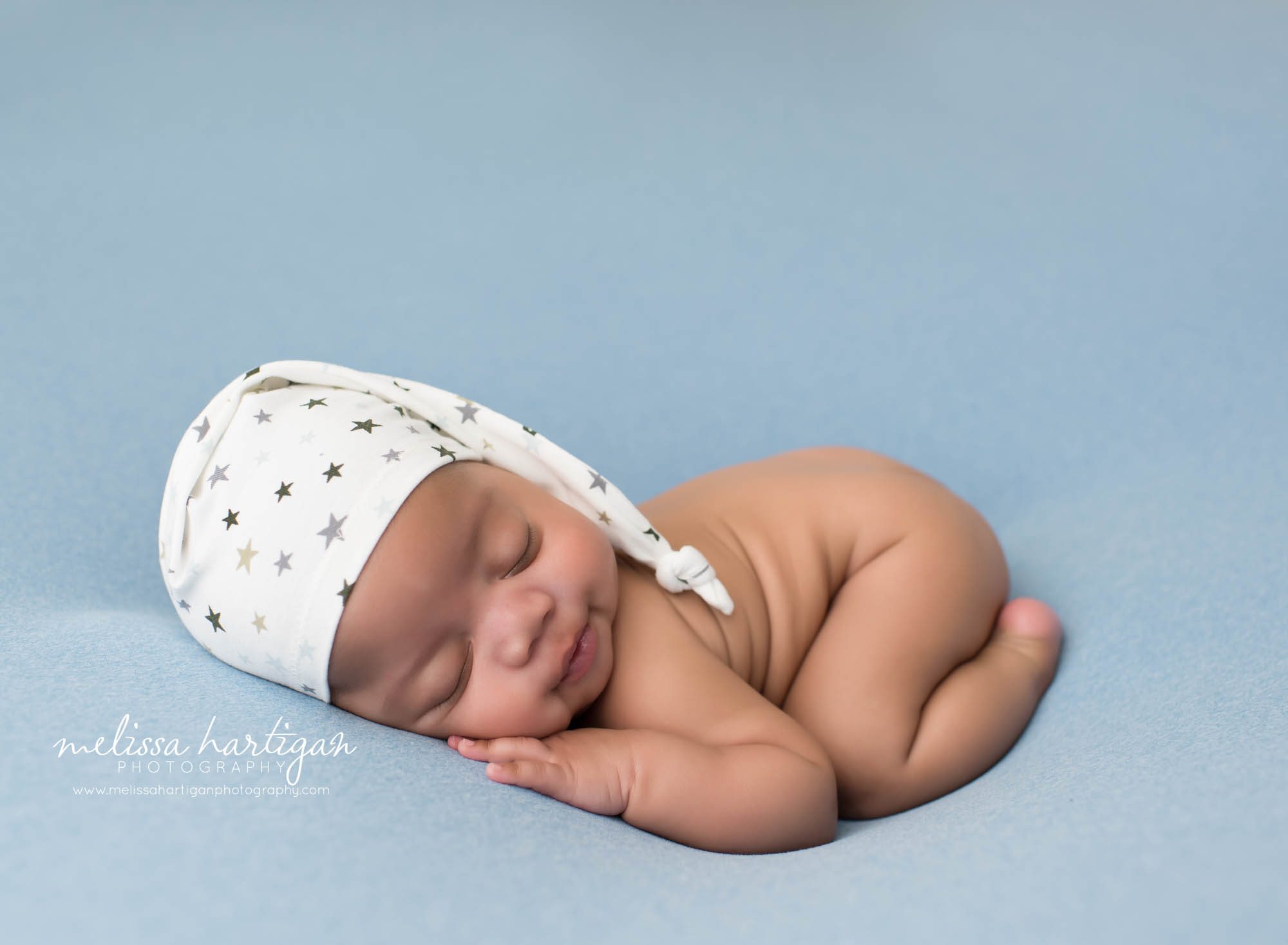 baby boy posed on tummy bum up opose with cream star newborn photography sleep cap