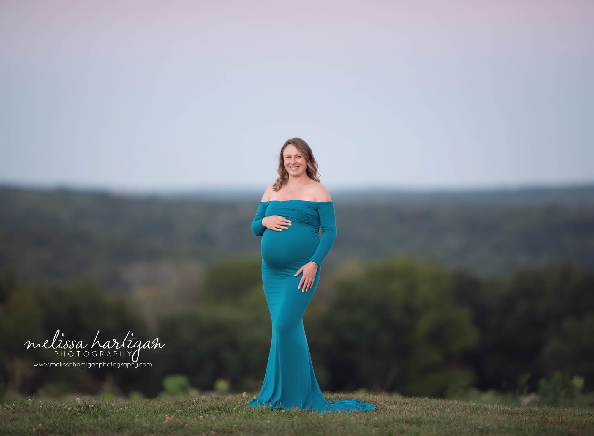 mom to be holding baby bump happy smiling at camera maternity photography CT