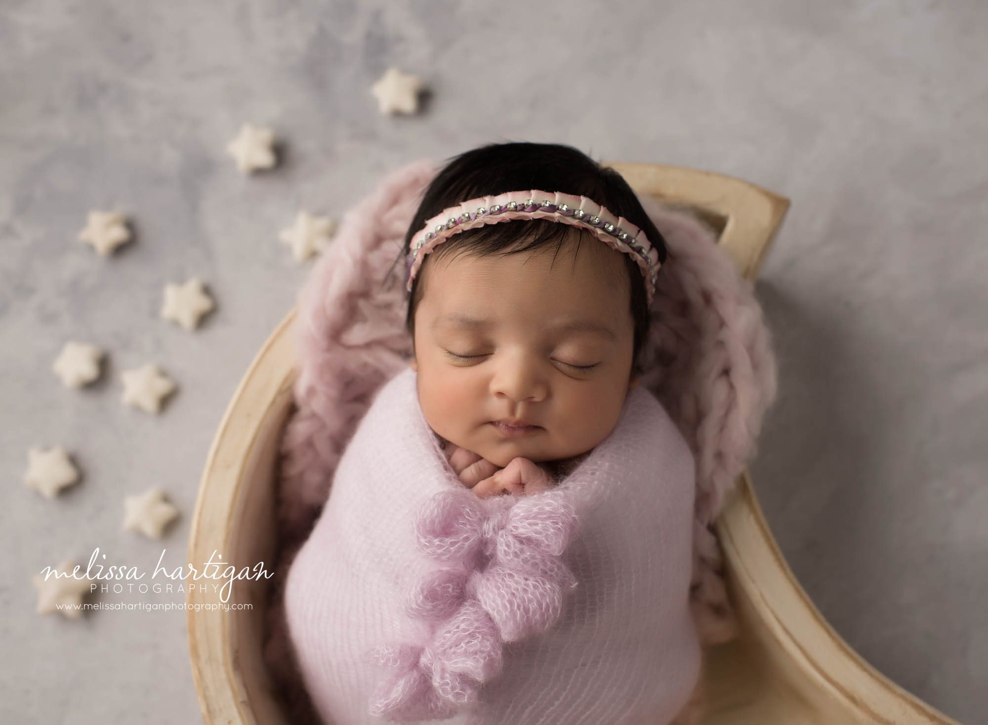 newborn abby girl wrapped in light pink light purple knitted wrap with cream star props