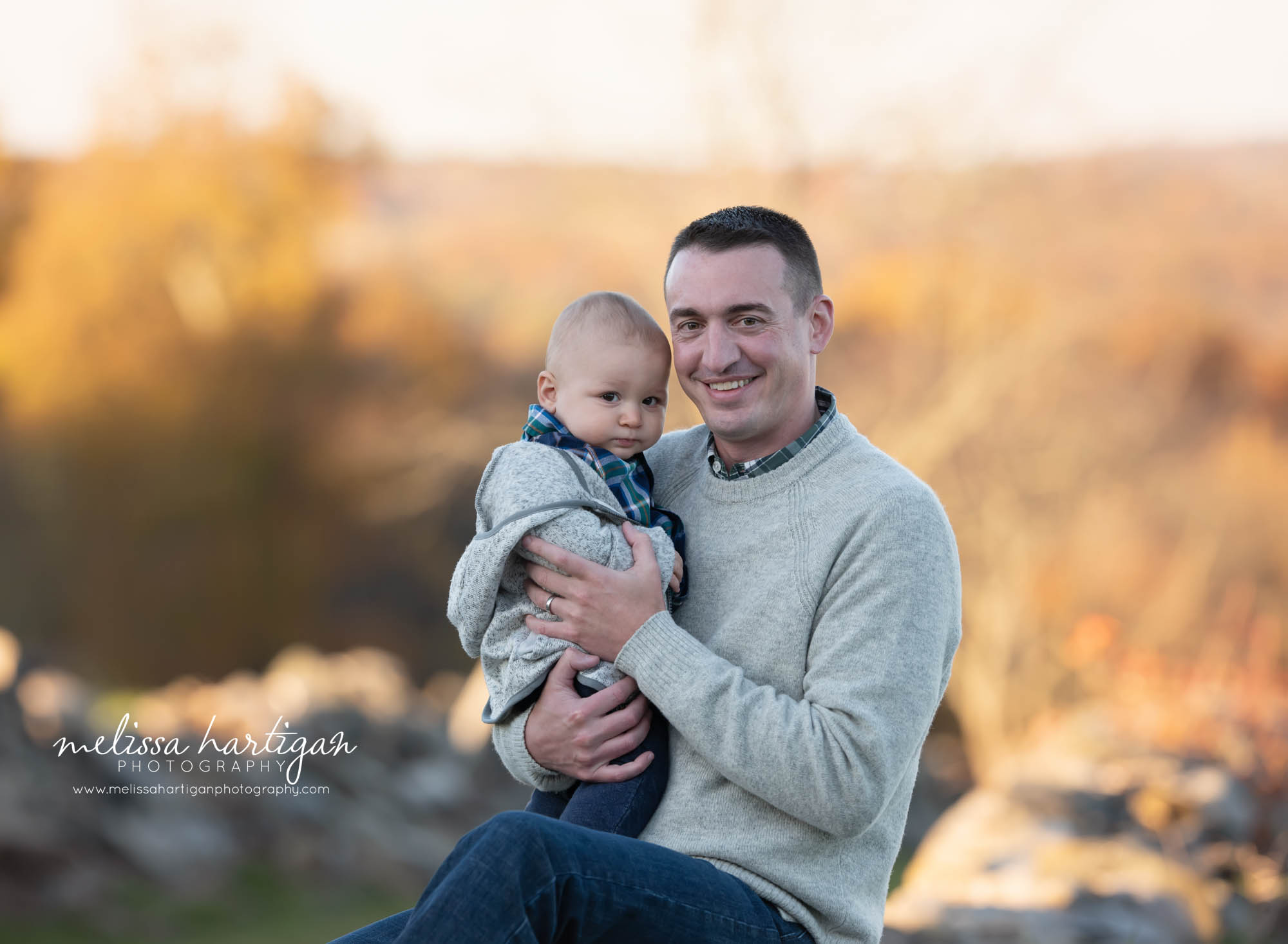 Dad holding his baby boy during family session outdoors in fall