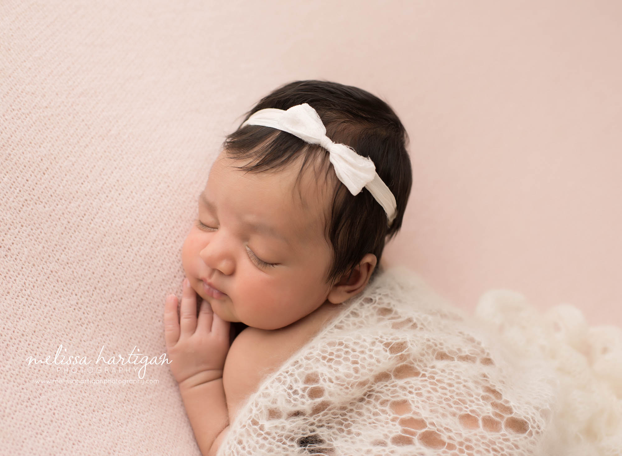 baby girl posed on pink backdrop with knitted cream draping layer Hartford country CT newborn Photographers