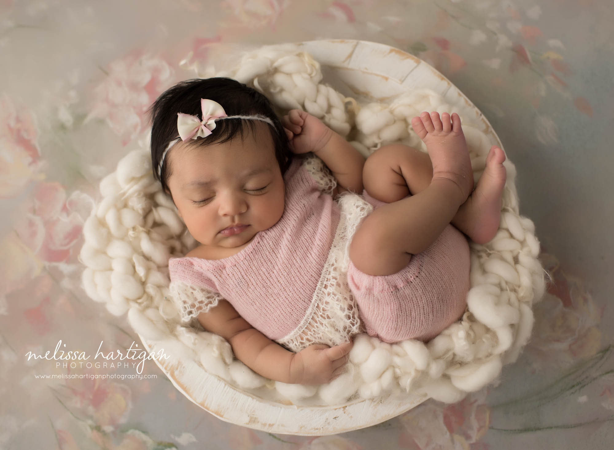 newborn baby girl wearing pink and cream knitted romper