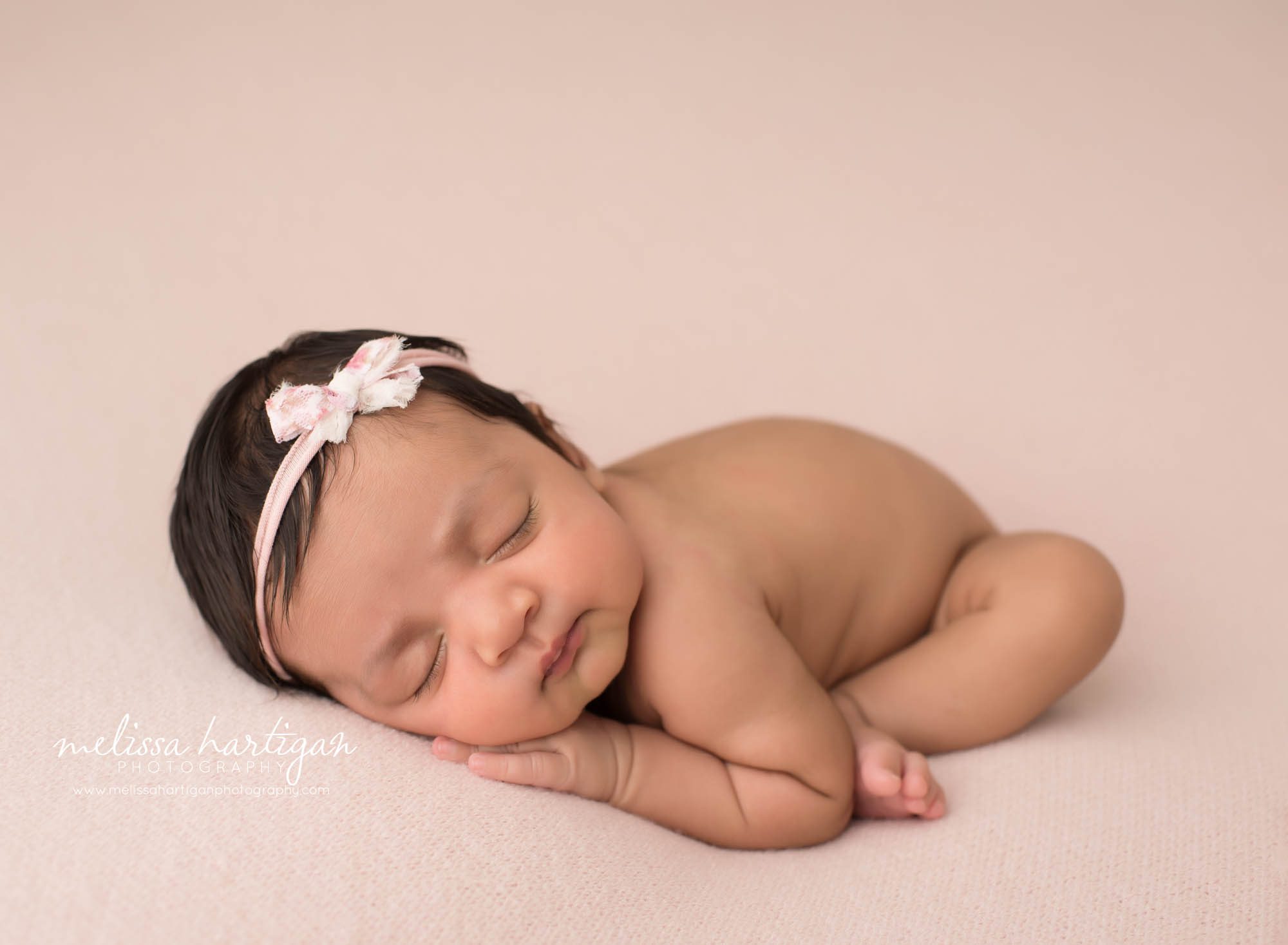 newborn baby girl posed on pink backdrop newborn photography pose taco