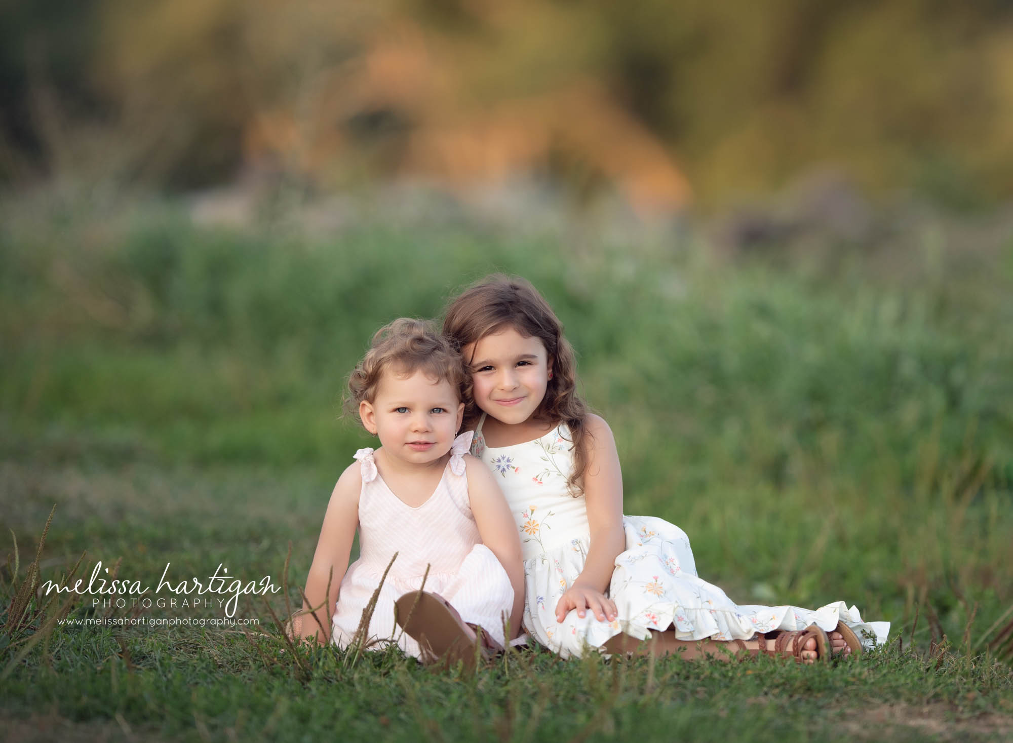 sister sitting together on grass outside family photography CT
