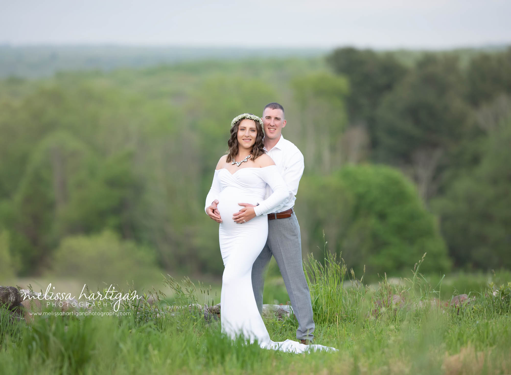 mom dad holding pregnant baby belly outside maternity photo