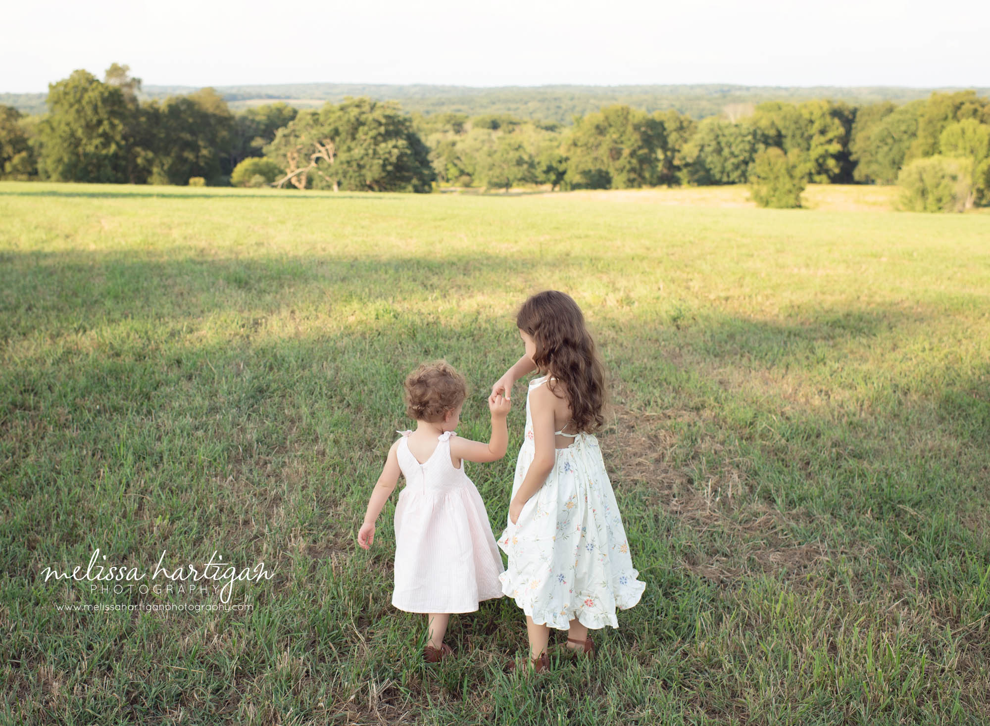 sisters holding hands outside family photo session in connecticut
