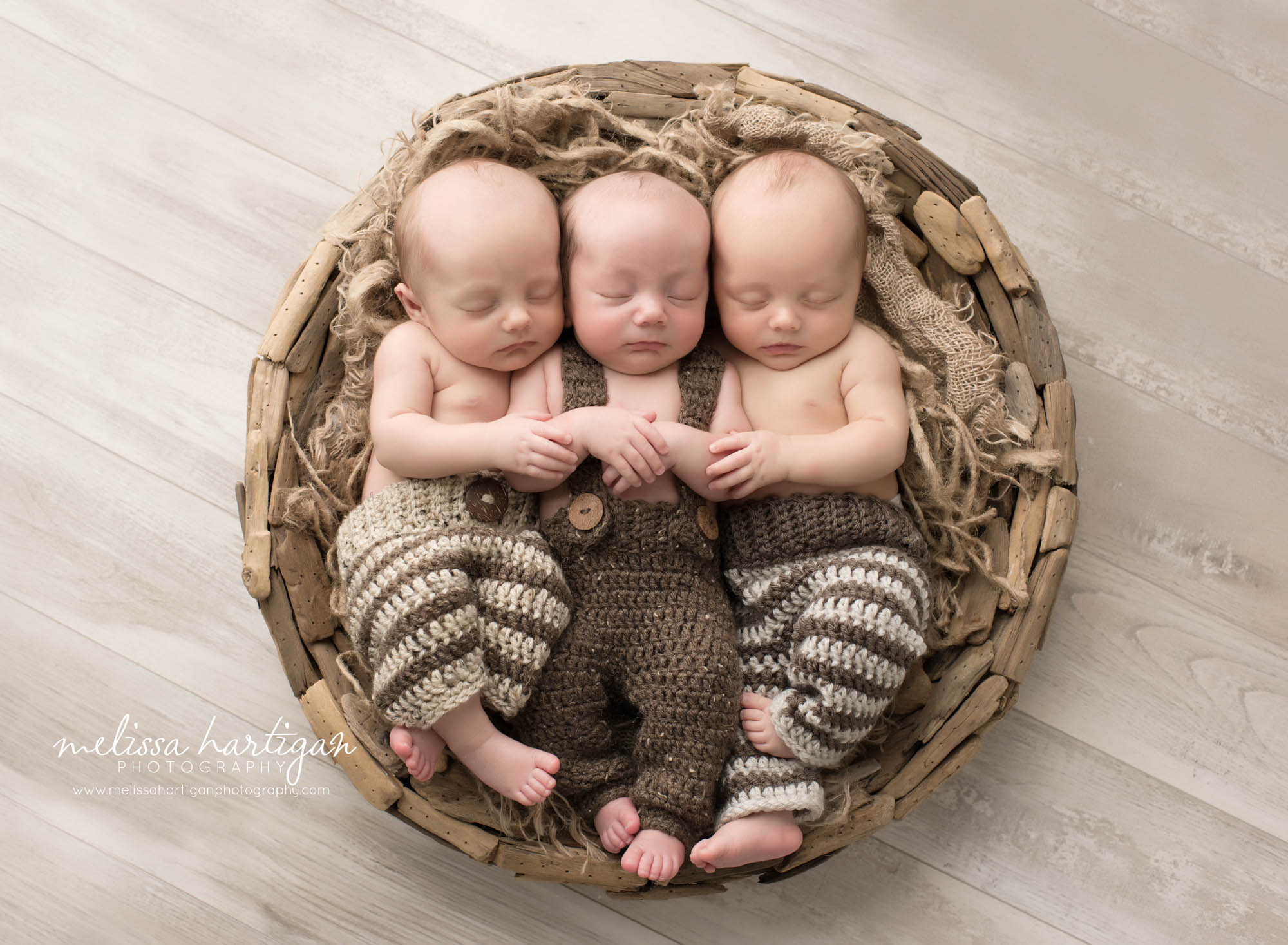 triplet newborn brothers sleeping in round bowl