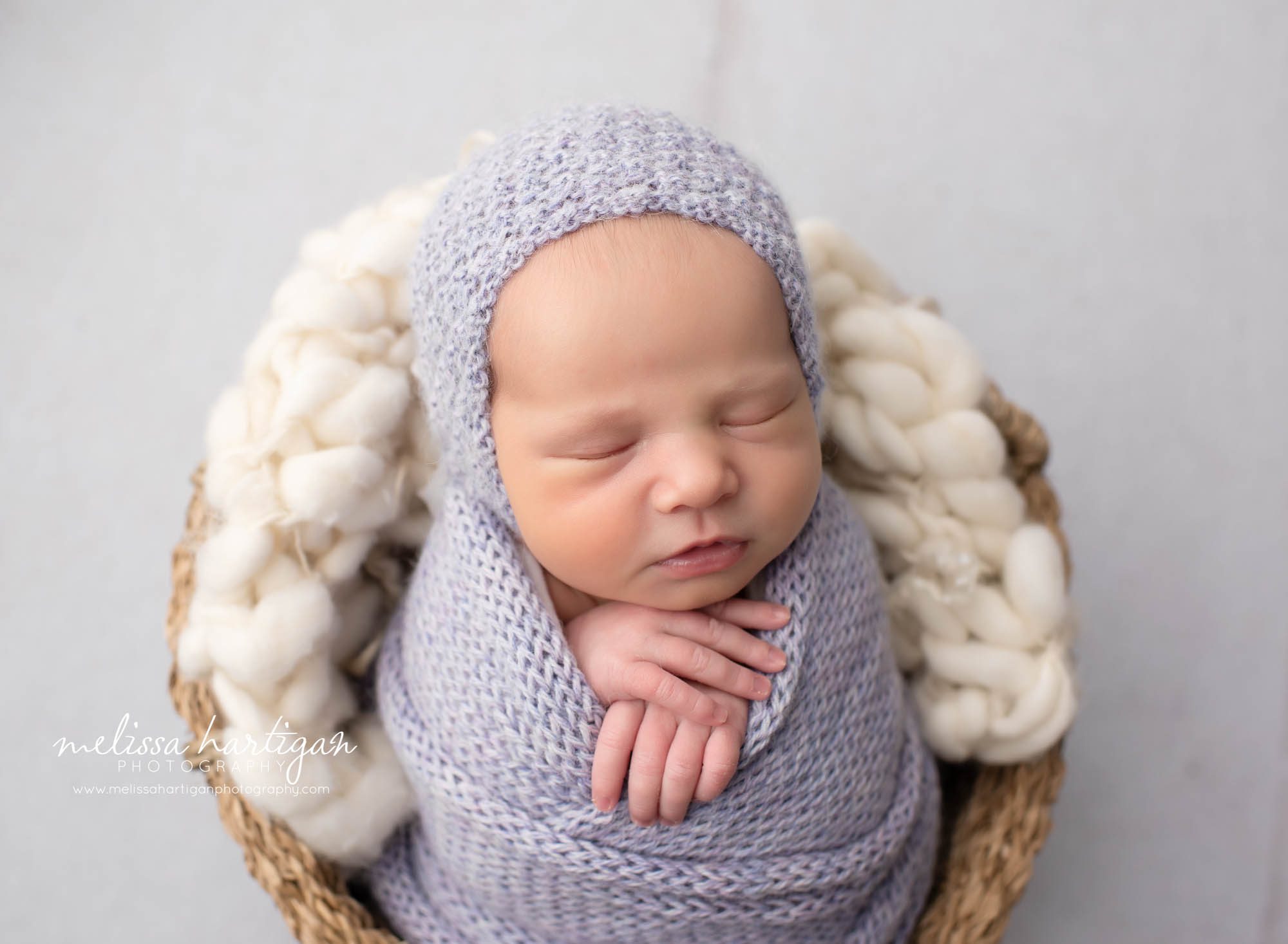 baby girl wrapped in light purple lilac color knitted wrap and matching knitted bonnet south windsor newborn photographer