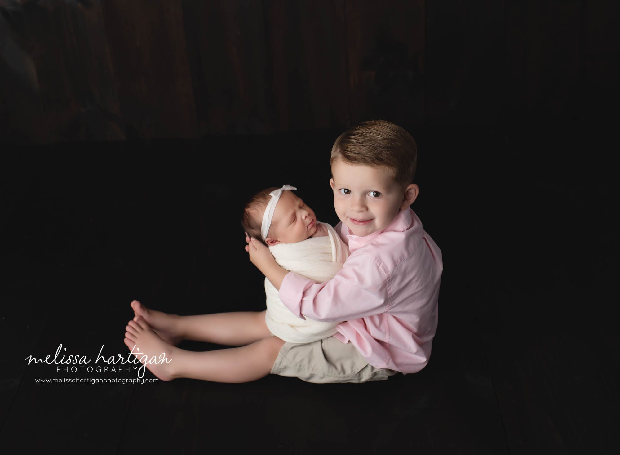 big brother holding newborn baby sister in studio newborn photography session CT newborn Photographer