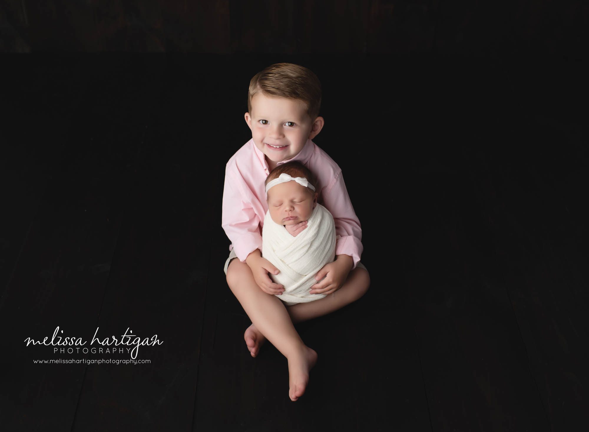 big brother holding newborn baby sister in studio newborn photography session CT newborn Photography