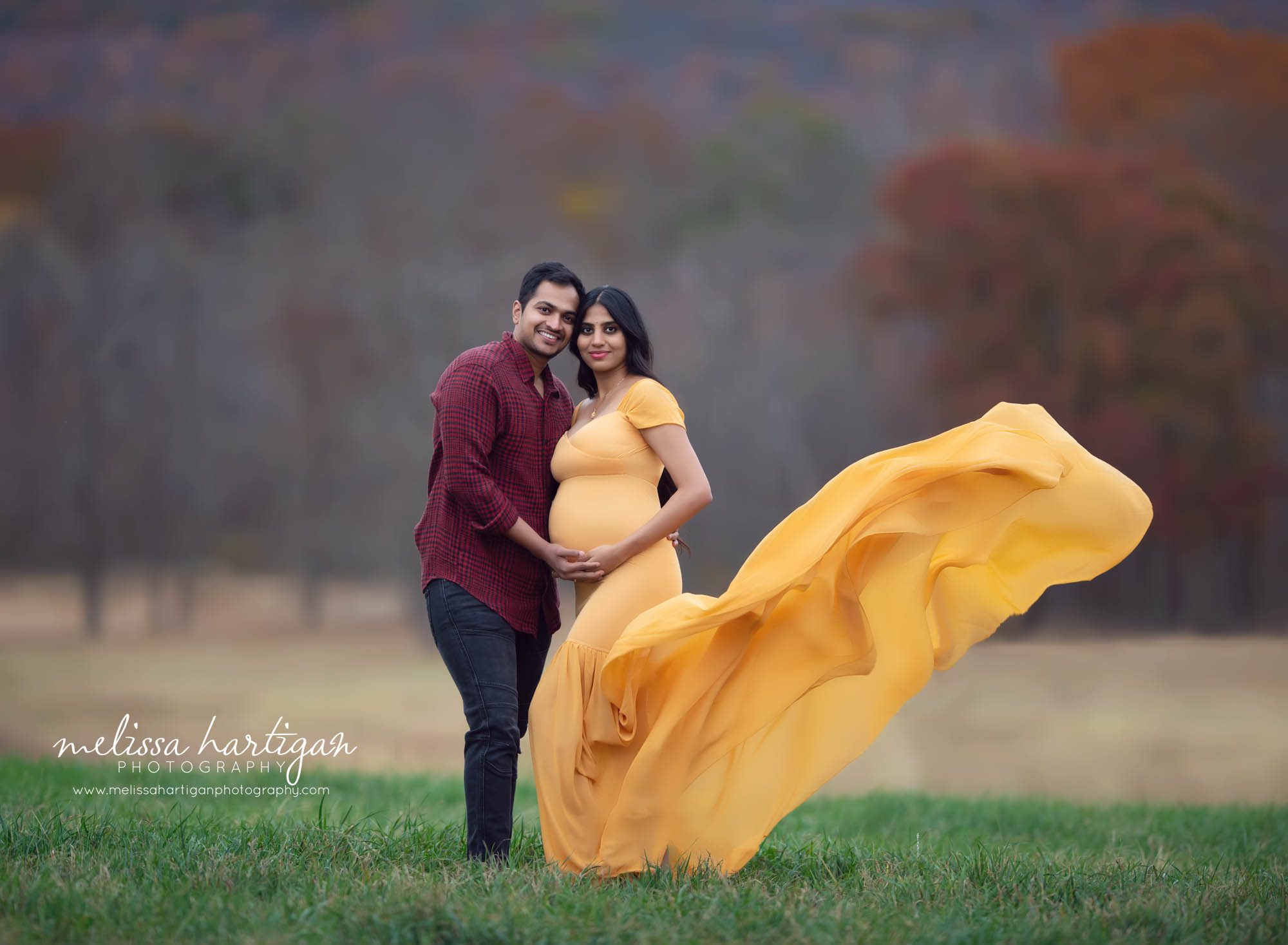 smiling happy couple standing maternity picture outdoors long form fitting maternity gown maternity Photographer CT