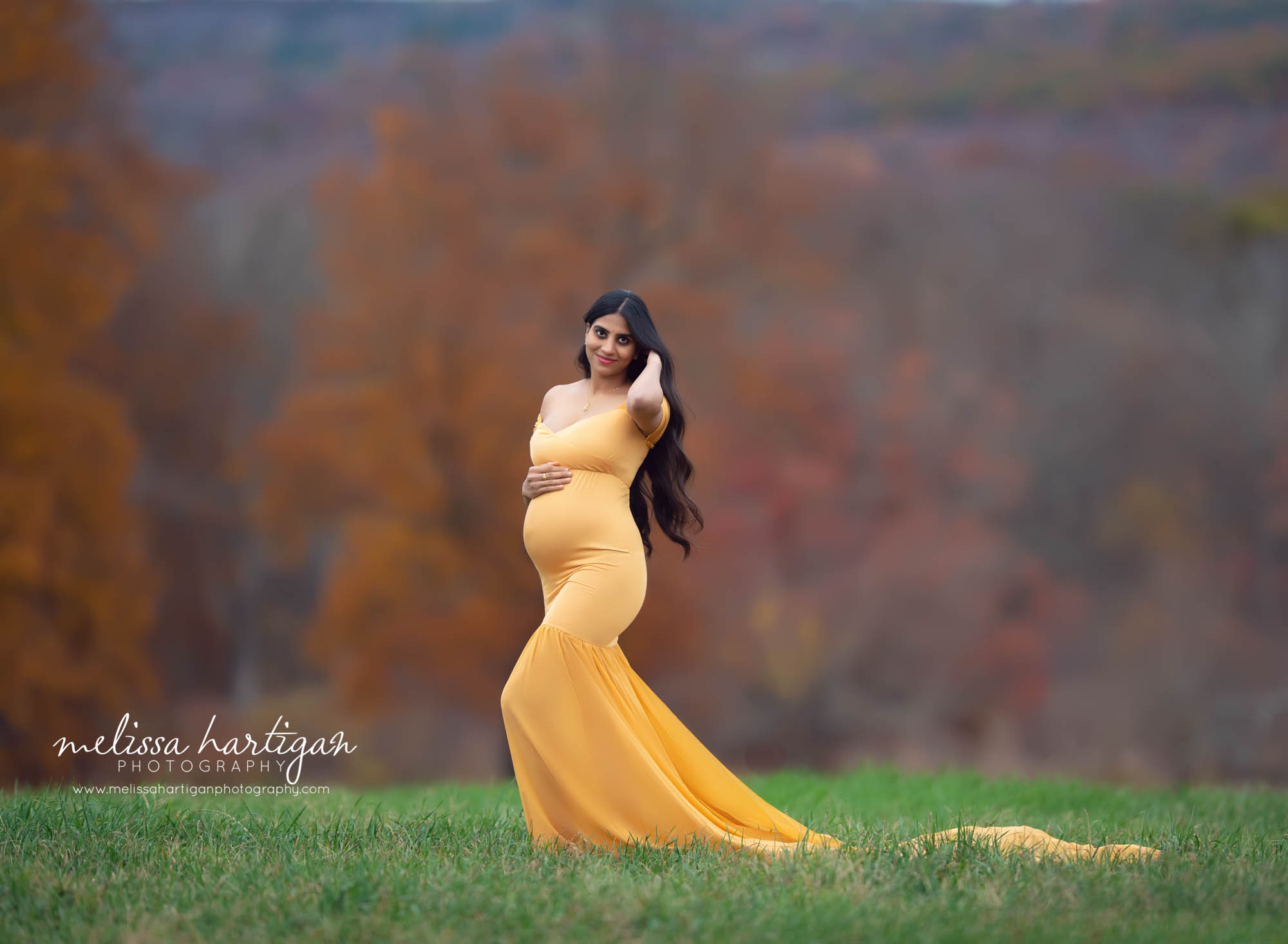 expectant mama holding baby bump standing maternity picture