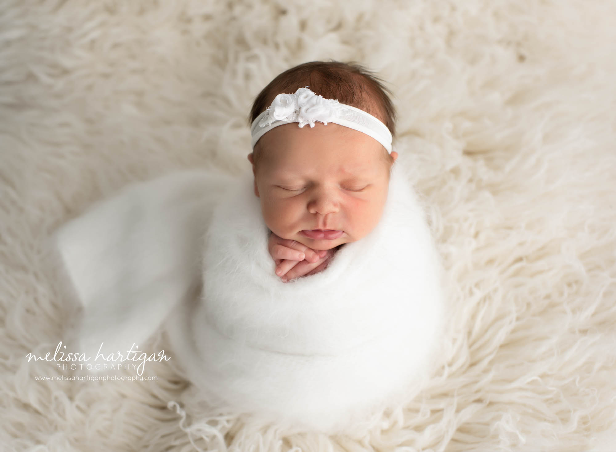 newborn baby girl wrapped in white knitted wrap with cream flokati hartford county ct newborn photography