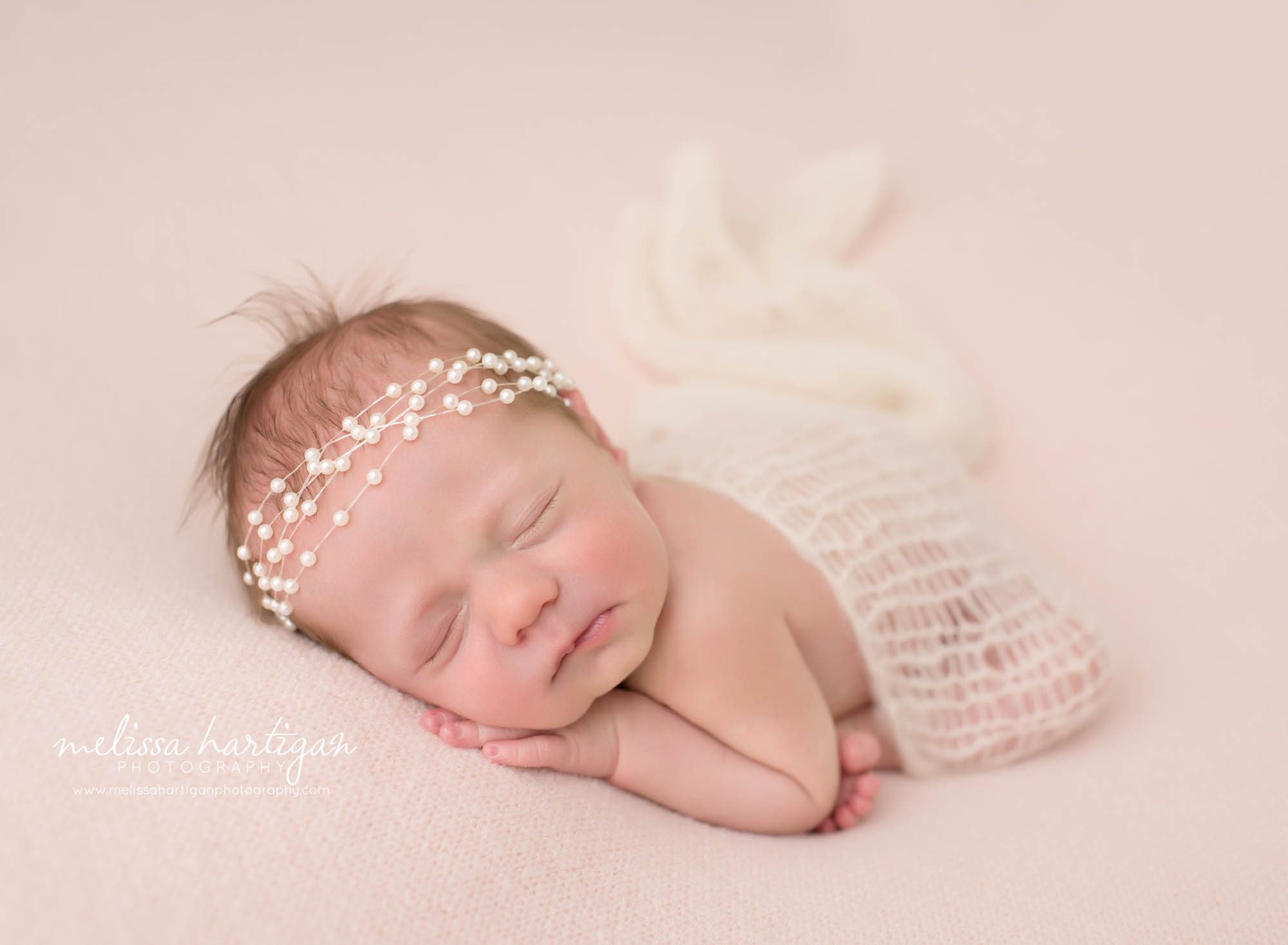 baby girl posed on tummy with knitted layer draped over her back Pearl headband Newborn Photography Massachusetts