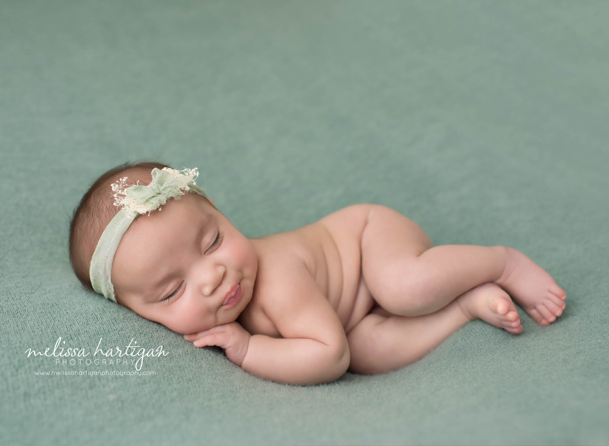 newborn baby girl posed on side with teal green colored flower headband Windsor CT newborn Photography