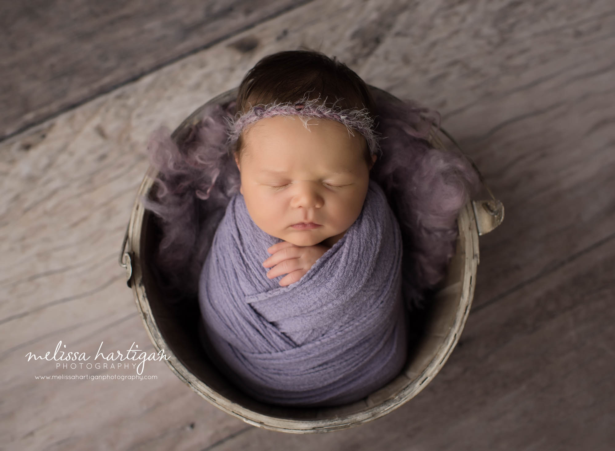 newborn baby girl wrapped in purple wrap posed in bucket CT baby photography