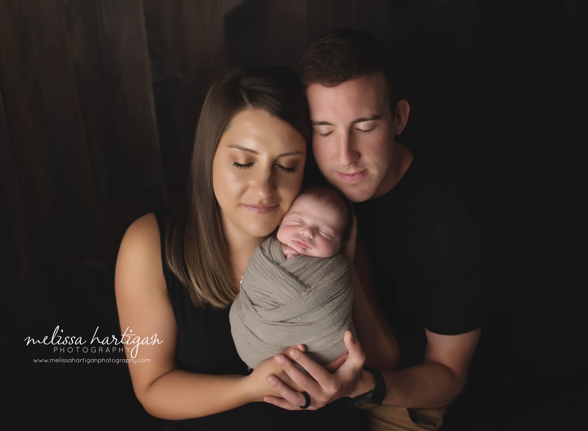 mom and dad holding newborn son wrapped studio newborn photography CT