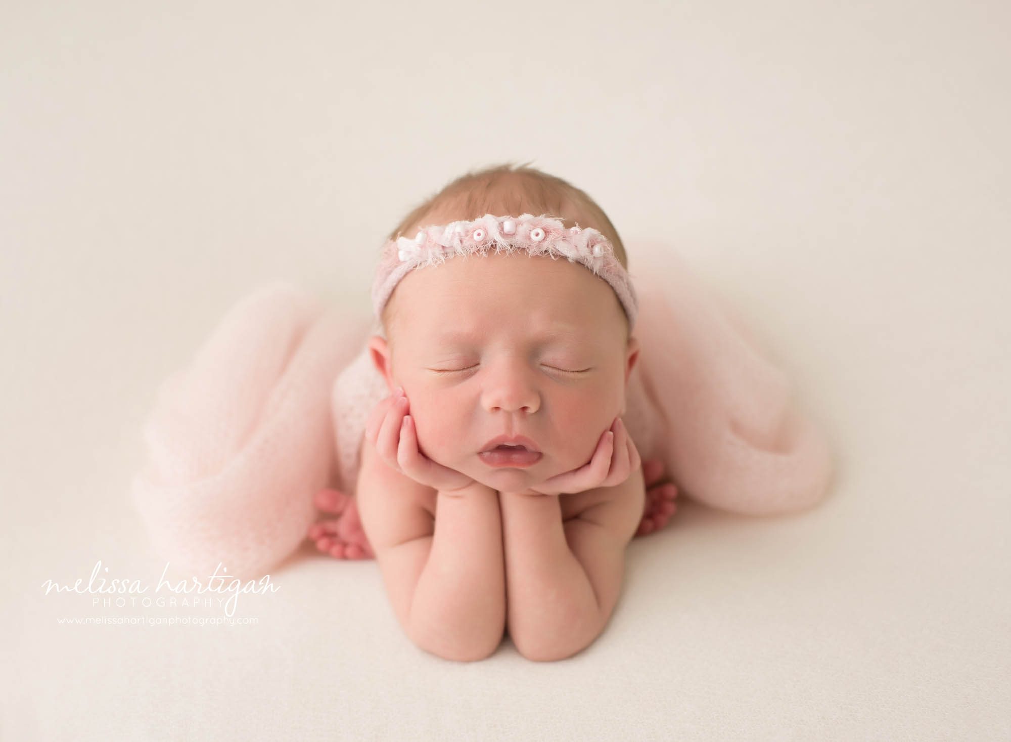 newborn baby girl posed froggy posed wearing pink beaded headband newborn photography hartford county