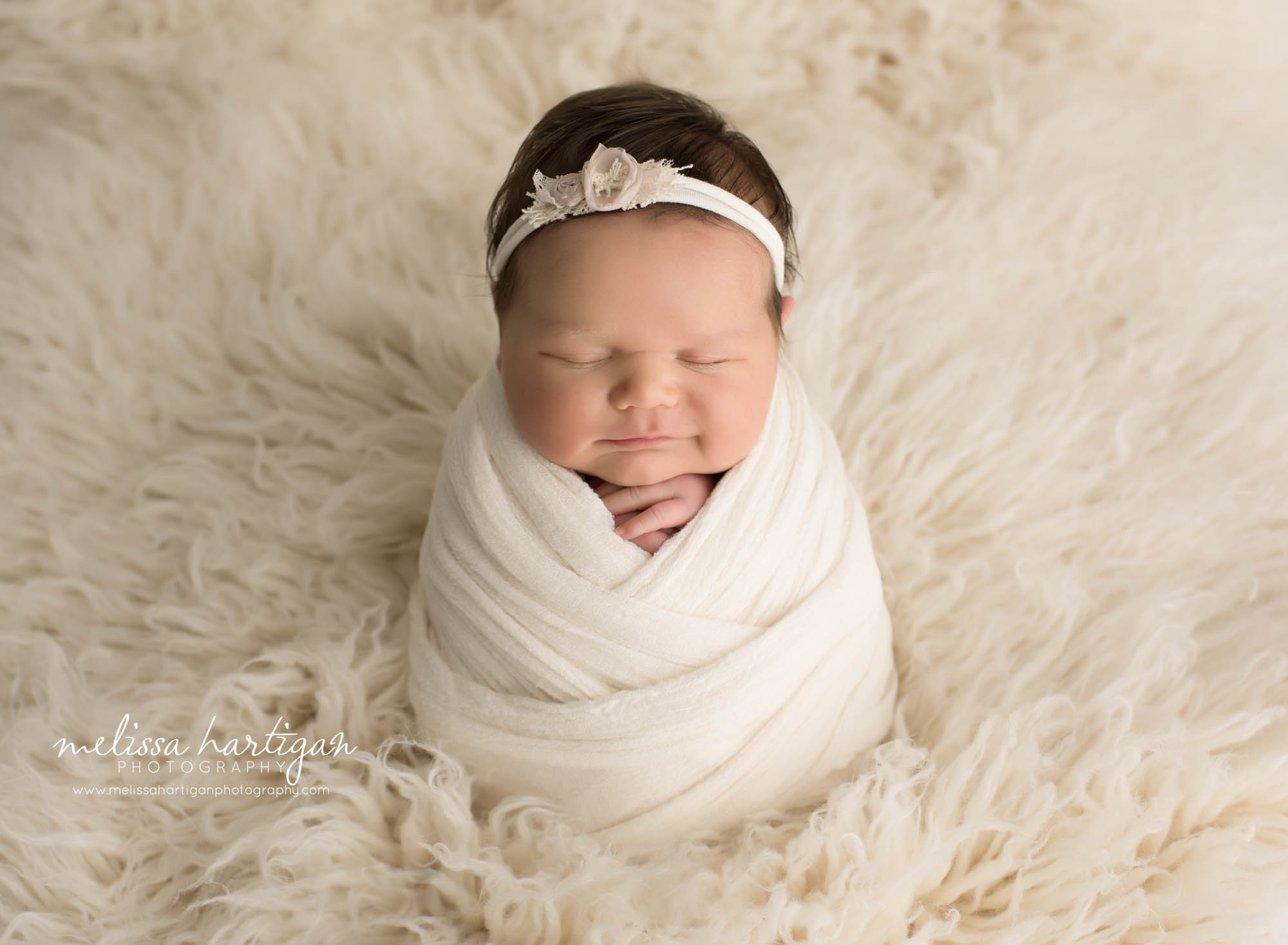 newborn baby girl wrapped in creal wrap with cream flower tie back newborn photography tolland county