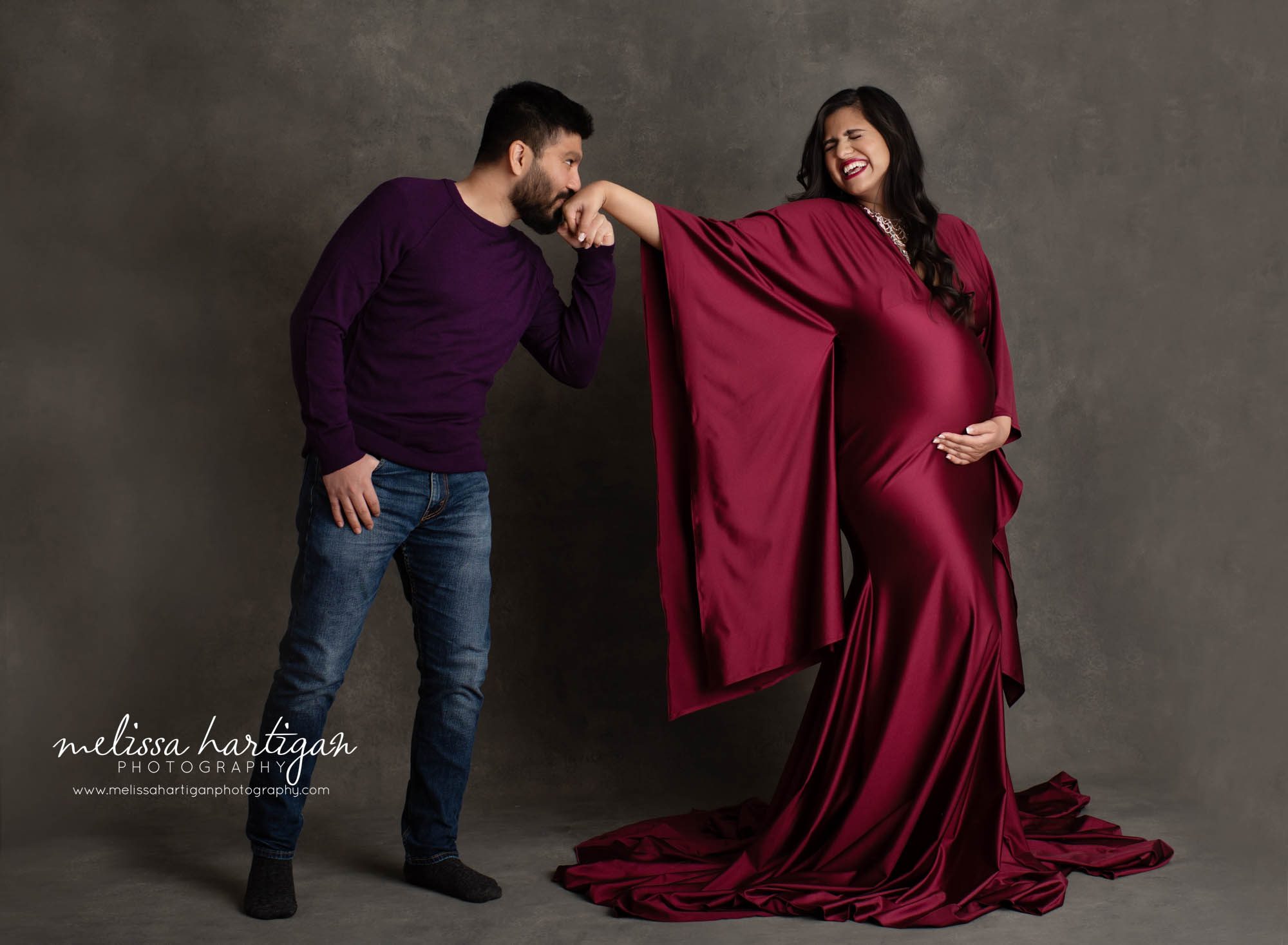 couples maternity pic dad kissing hand fun romantic maternity pose mom happy laughing beautiful pregnancy picture