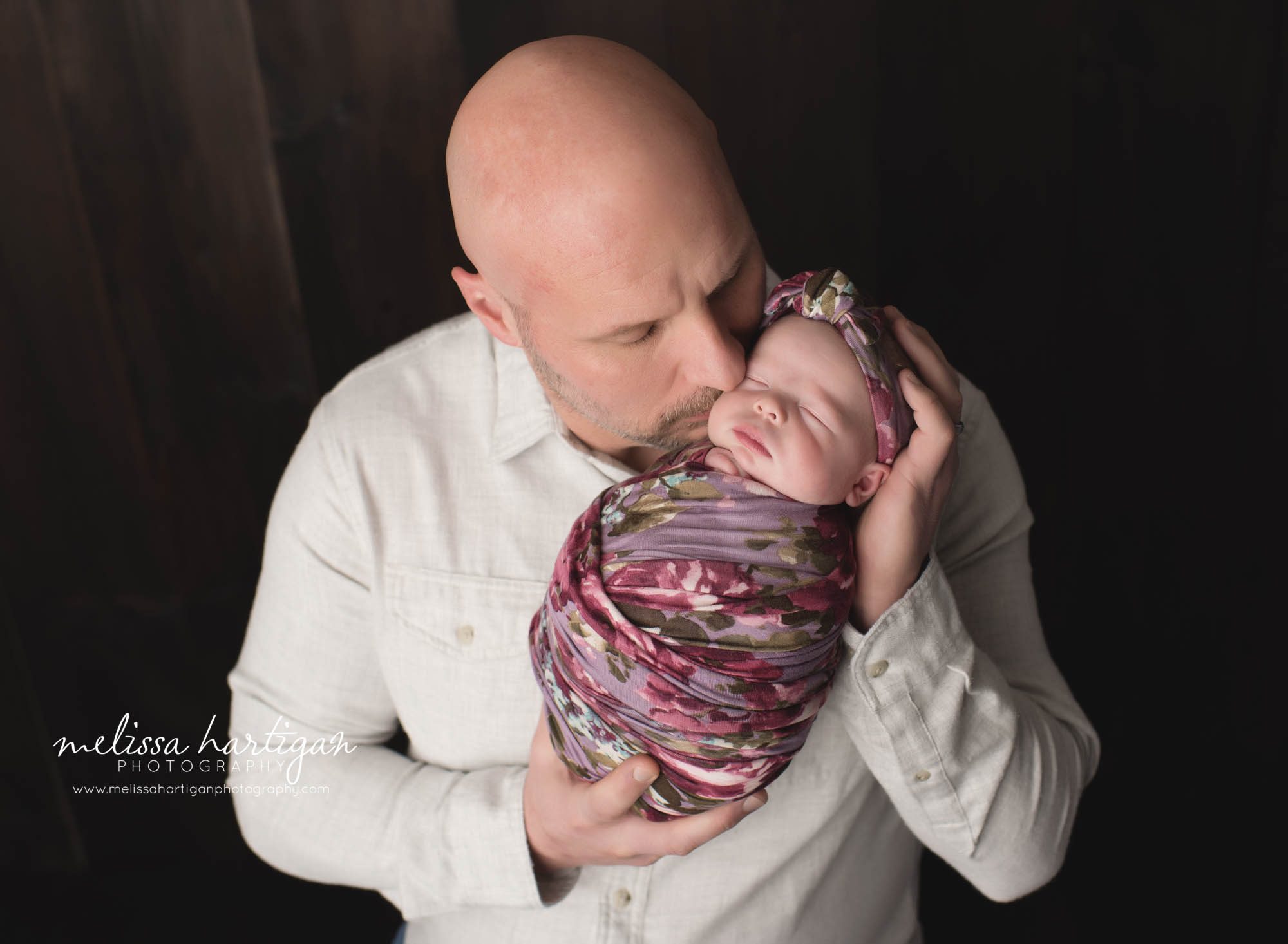 dad holding newborn daughter kissing her on the cheek CT newborn Baby photographer