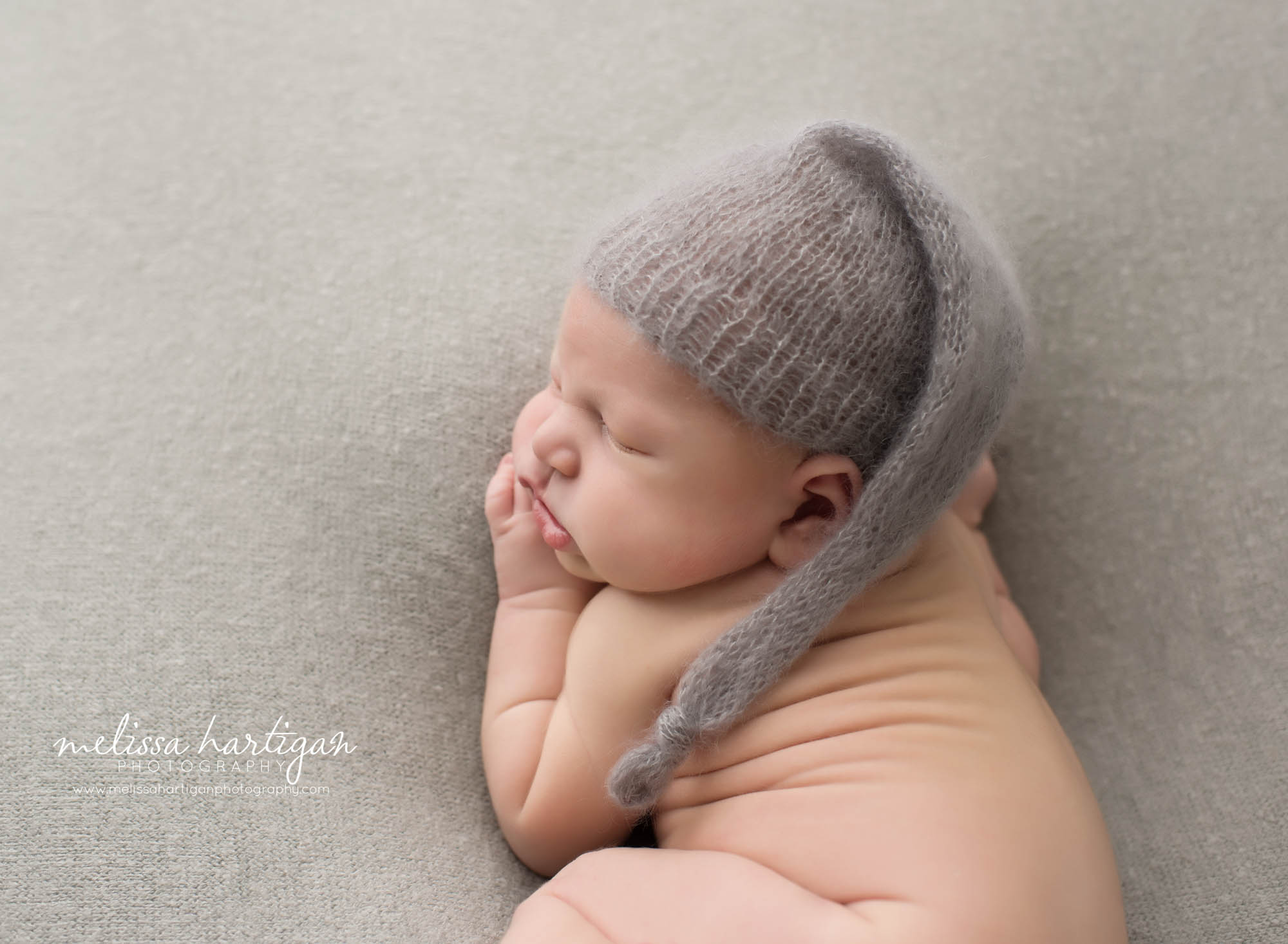 newborn baby boy posed on side with knitted gray sleepy cap norwalk CT newborn Photography