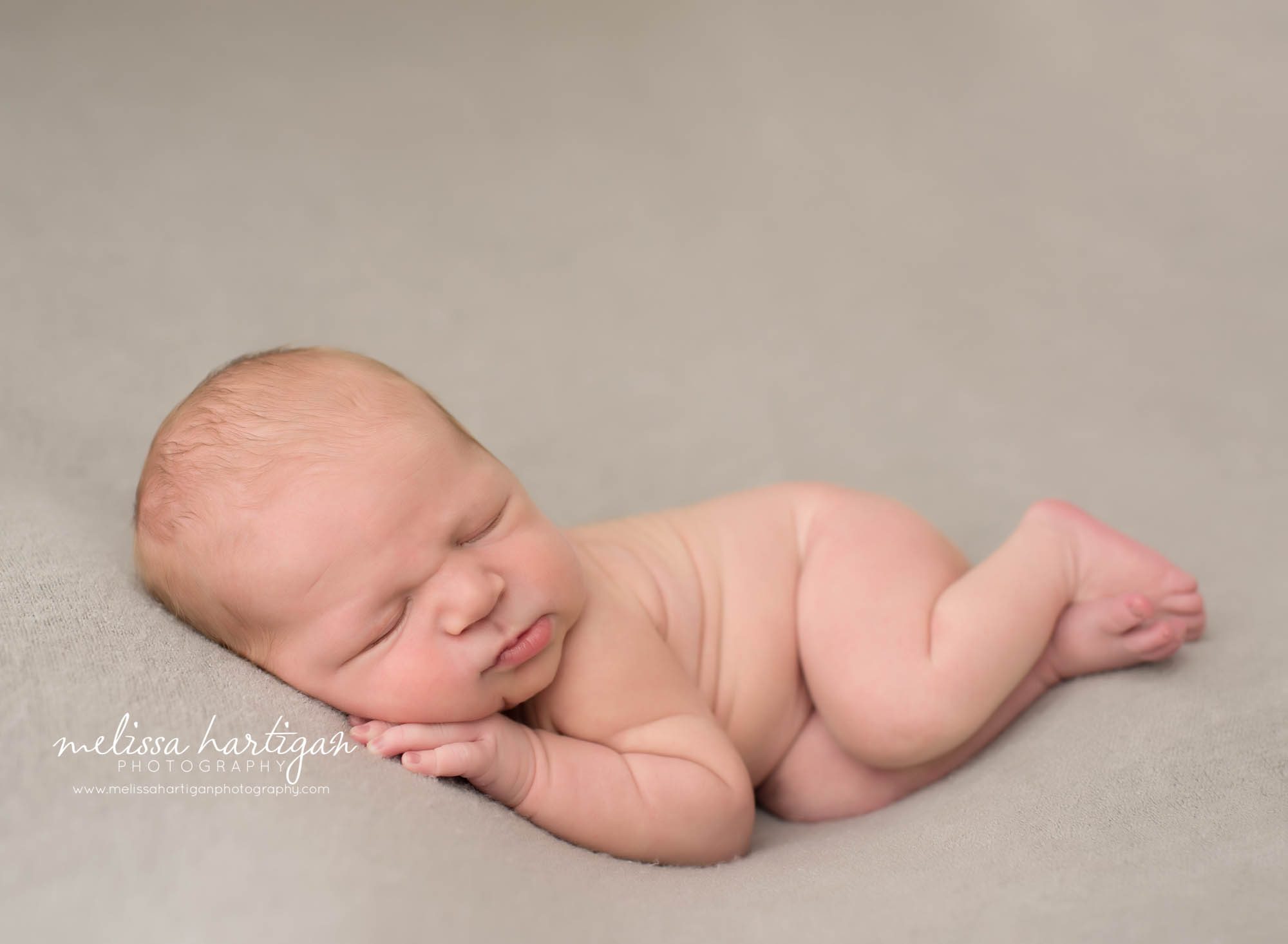newborn baby boy posed on side on gray backdrop norwalk newborn photography