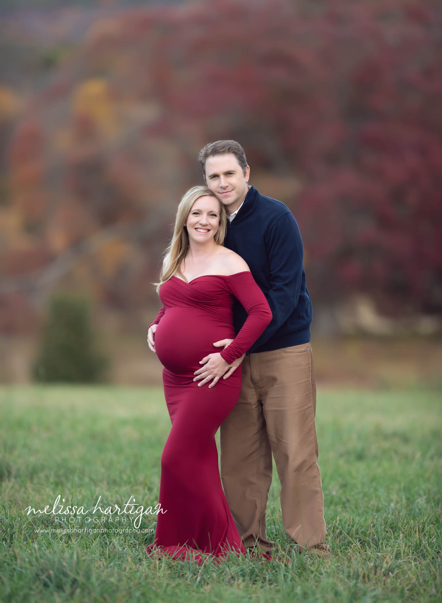 dad holding pregnant mom standing behind her happy couple CT maternity newborn photography