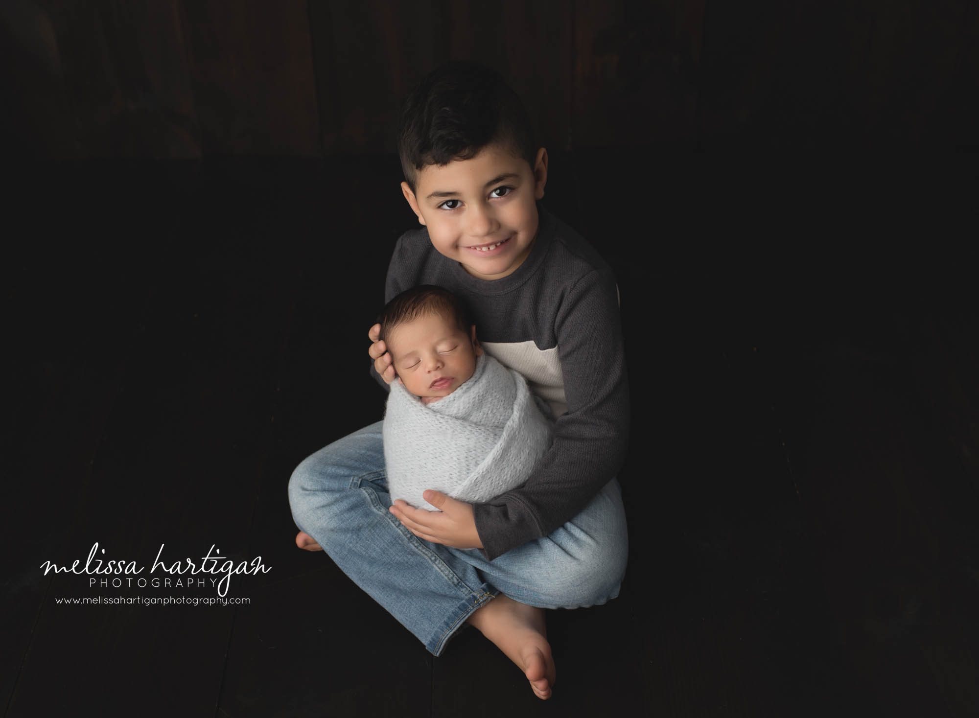 big brother holding baby brother studio newborn photography session