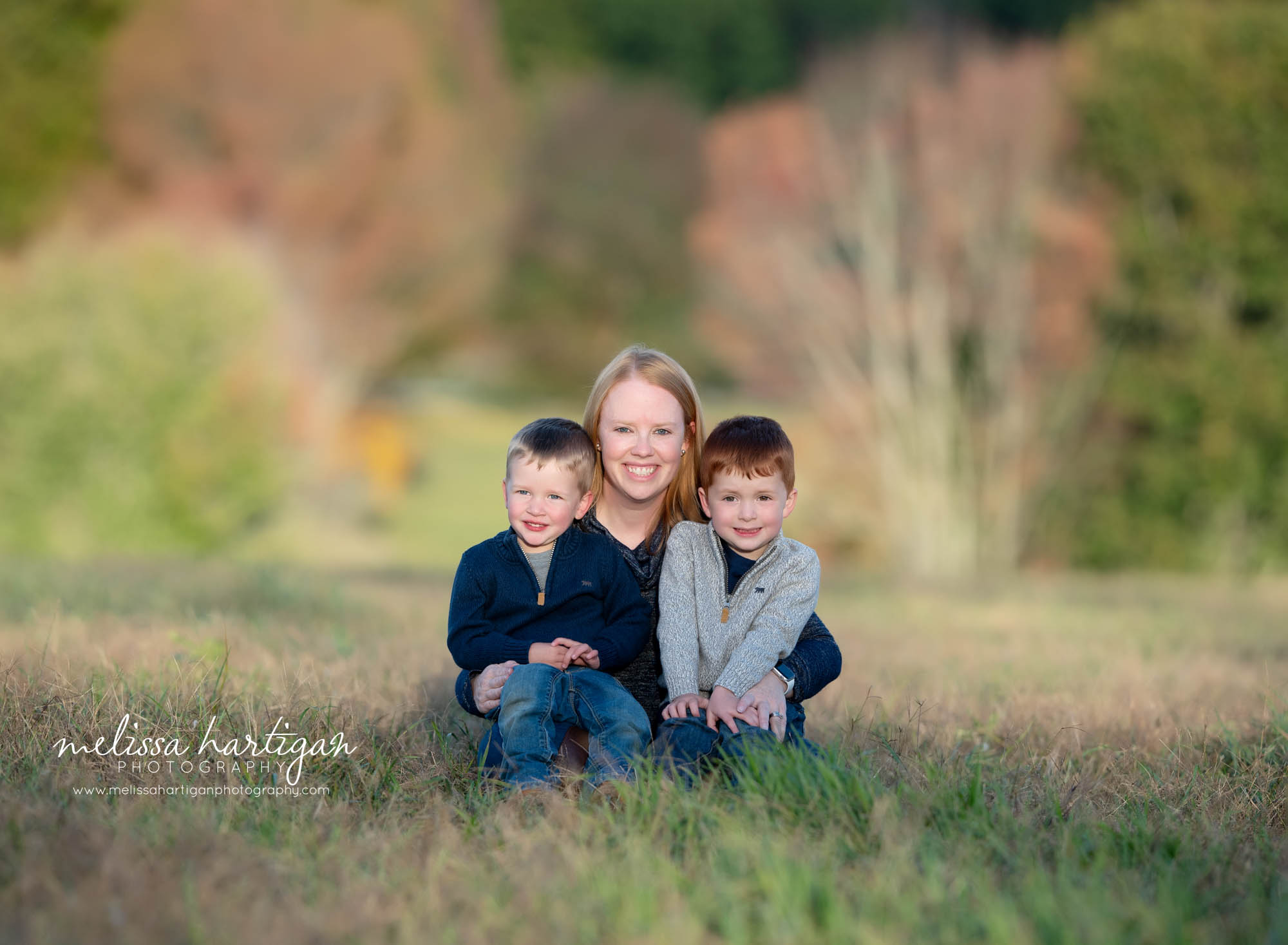 mom and two sons sitting family pose