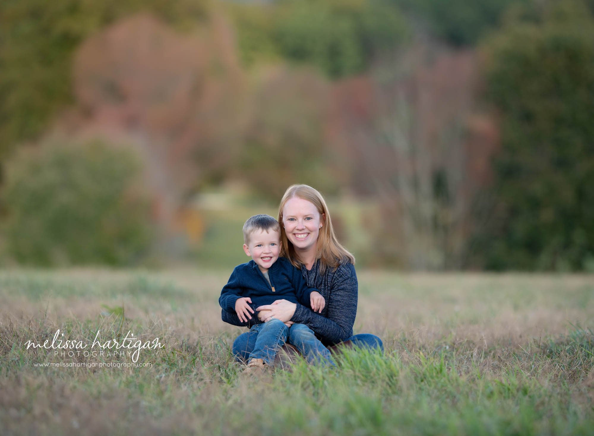 mom and young son sitting in grass family photographer middlesex county CT