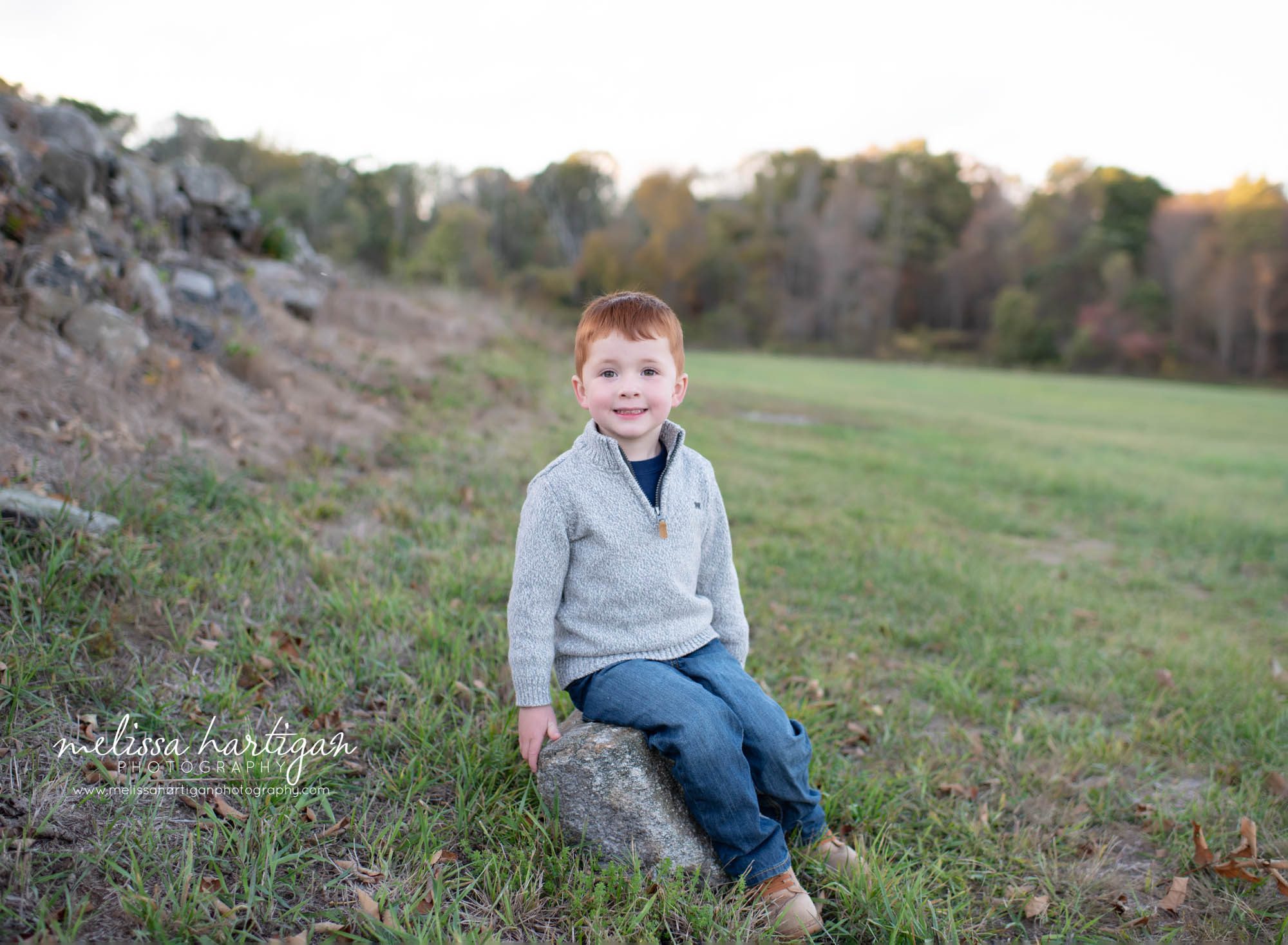 boy sitting on rock in park middlesex county family photography