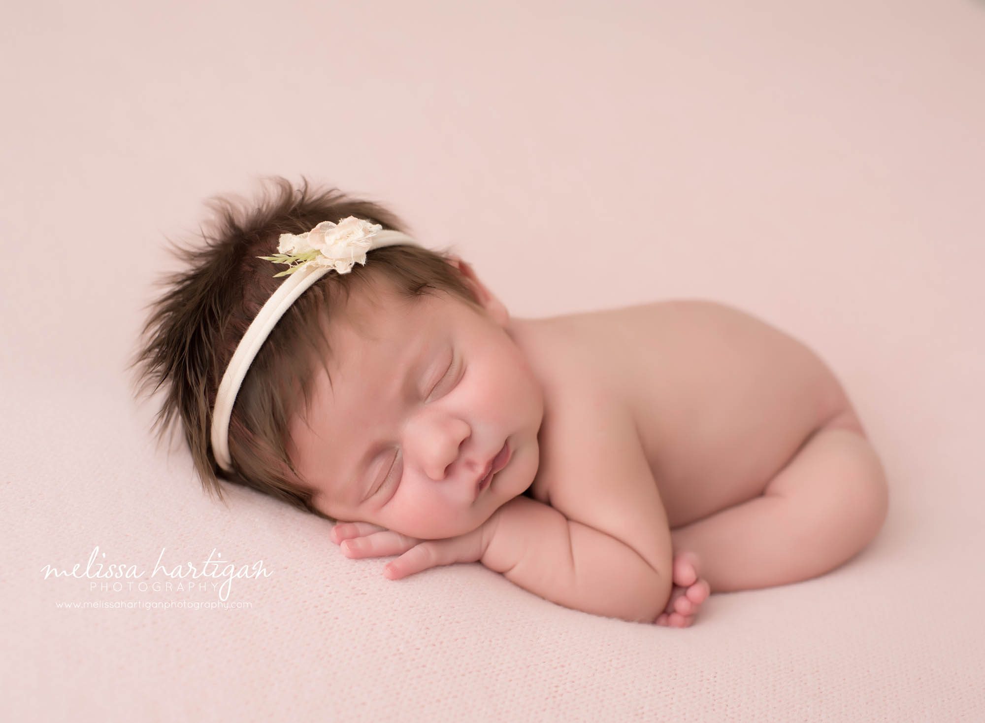 newborn baby girl modified taco pose on pink backdrop with flower headband Newborn photography Tolland County CT