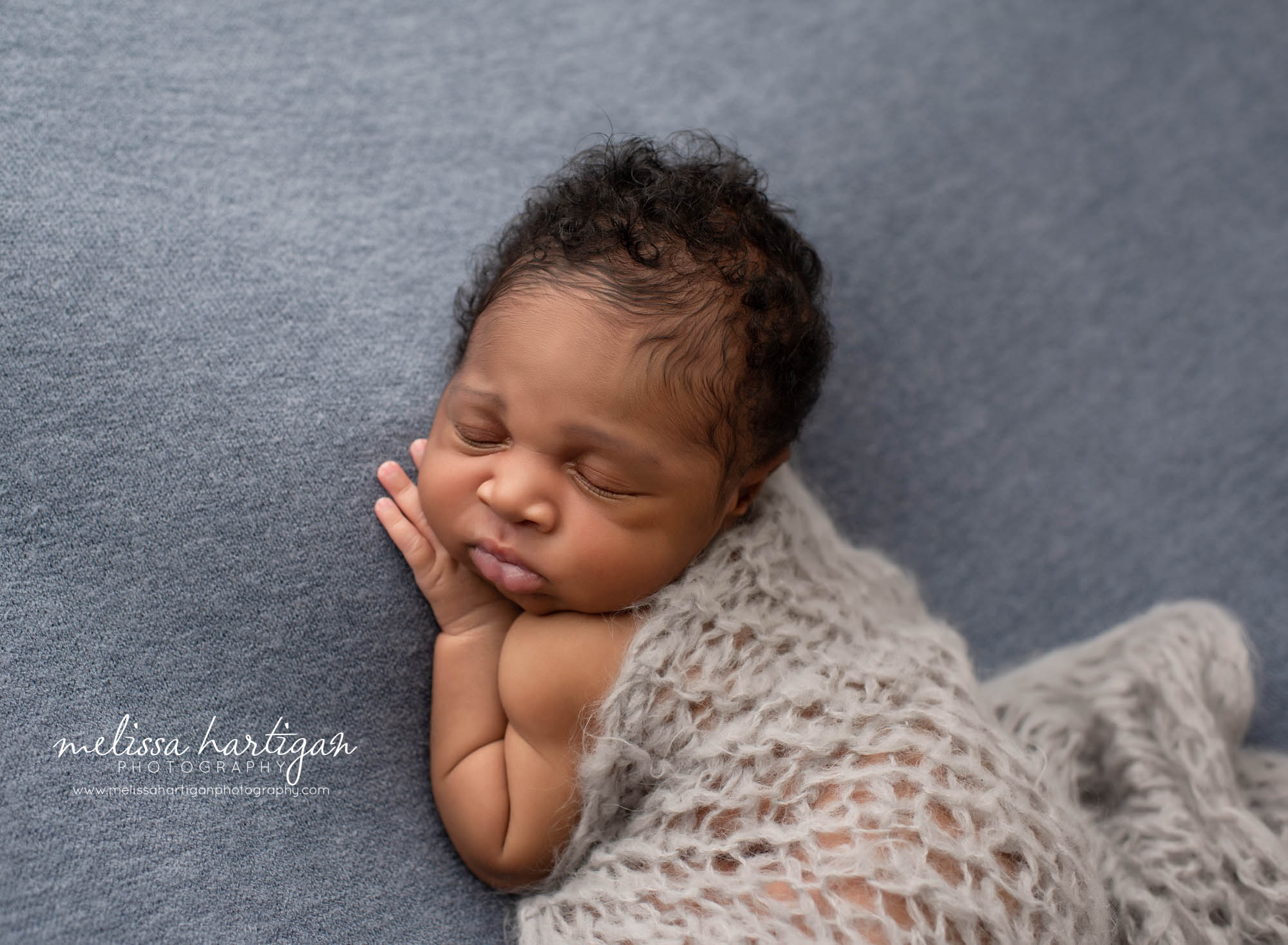 newborn baby boy posed on side with gray knitted wrap layered over back newborn photography windsor CT