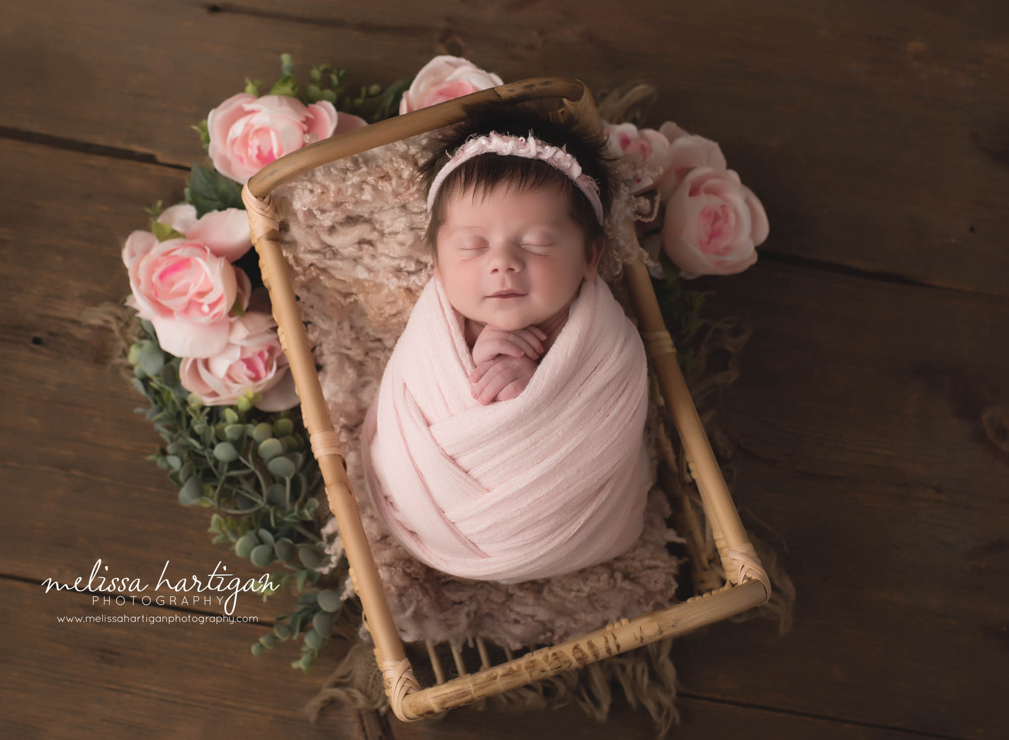 newborn baby girl posed in pink wrap posed in basket with pink layers and floral elements tolland county Newborn photography